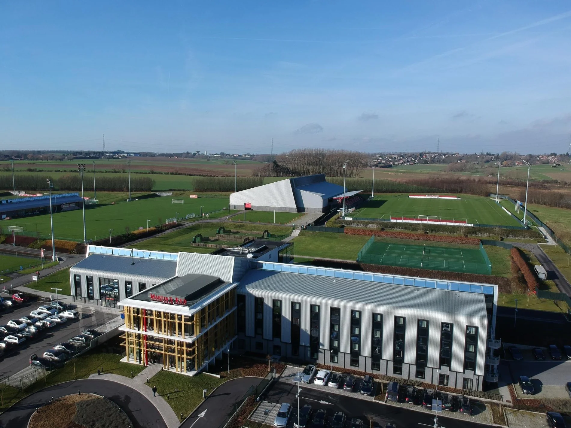 Vue aérienne de Martin's Red, un complexe moderne comprenant un hôtel et un terrain de sport dans un environnement spacieux.
