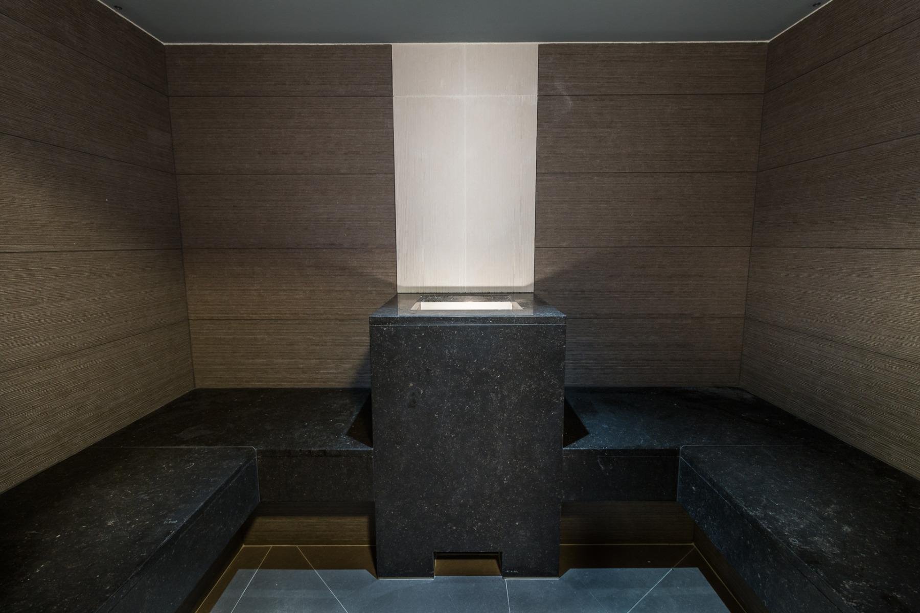 Moderne hammam met stenen muren en zachte verlichting voor een ontspannende sfeer.