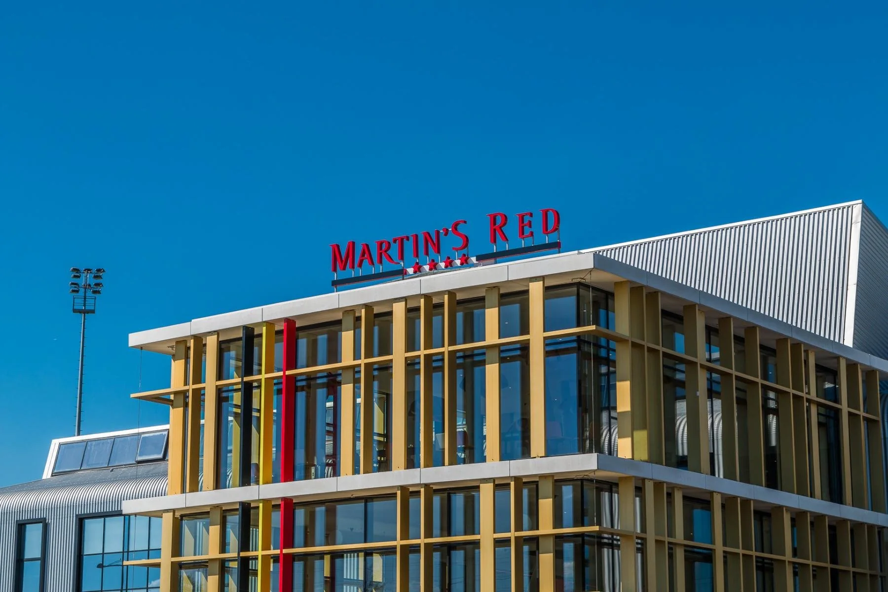 Façade de l'hôtel Martin's Red à Tubize sous un ciel bleu