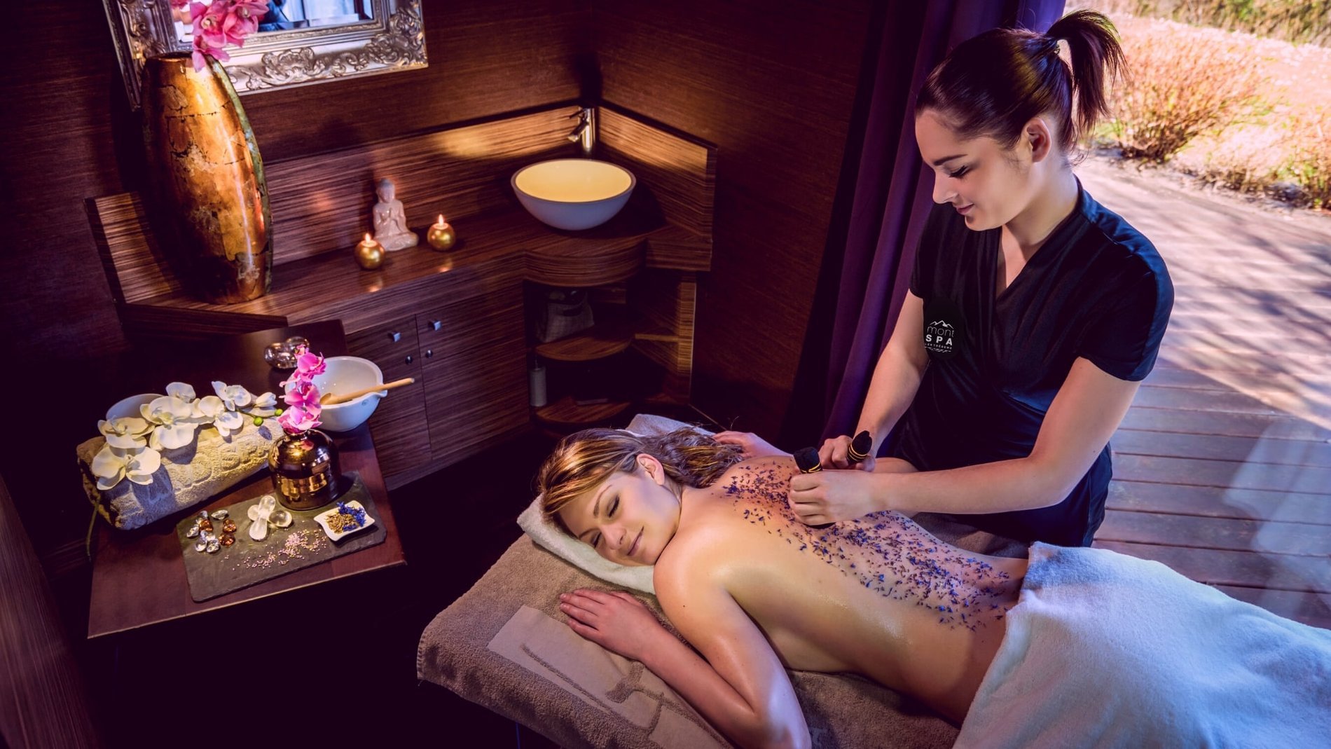 Massage du dos dans une cabine cosy au Mont Spa Les Trésoms à Annecy, atmosphère relaxante et naturelle.