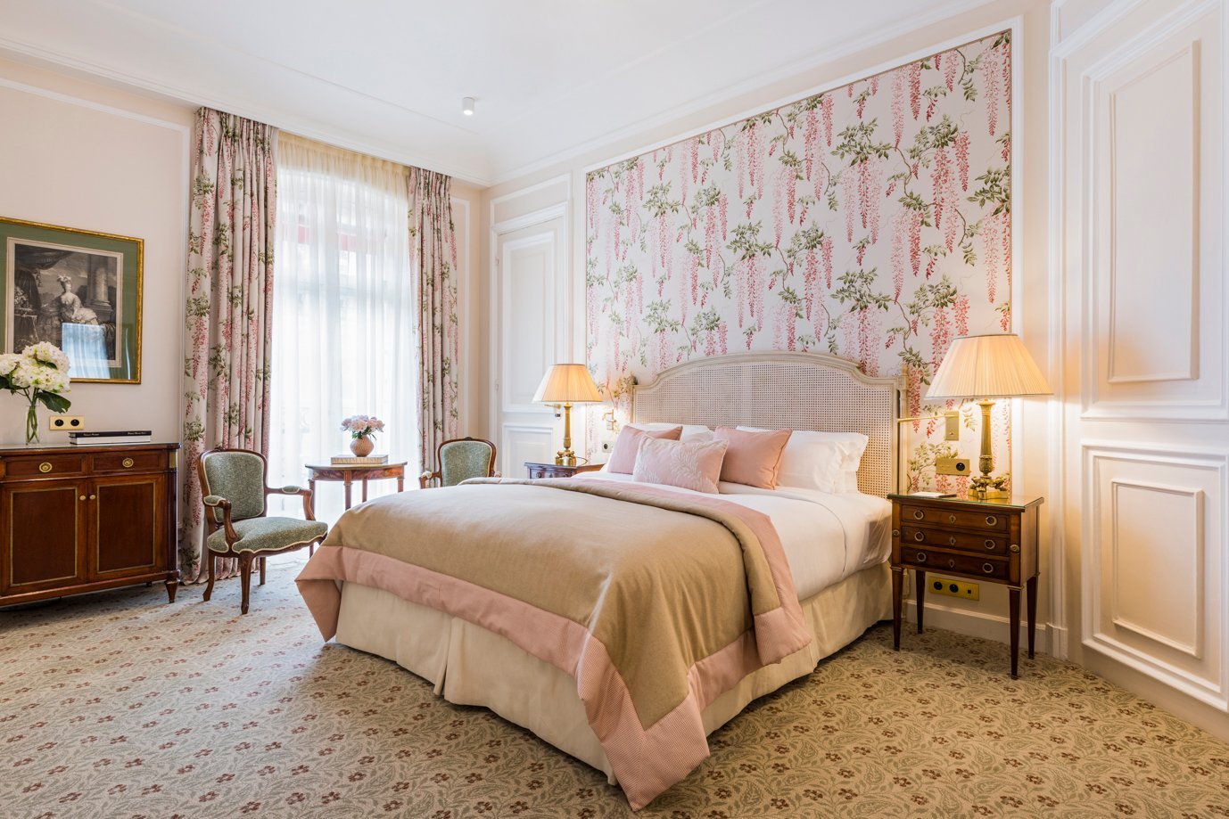Chambre deluxe lumineuse de l’Hôtel San Régis à Paris, décor floral mural et mobilier de style classique.