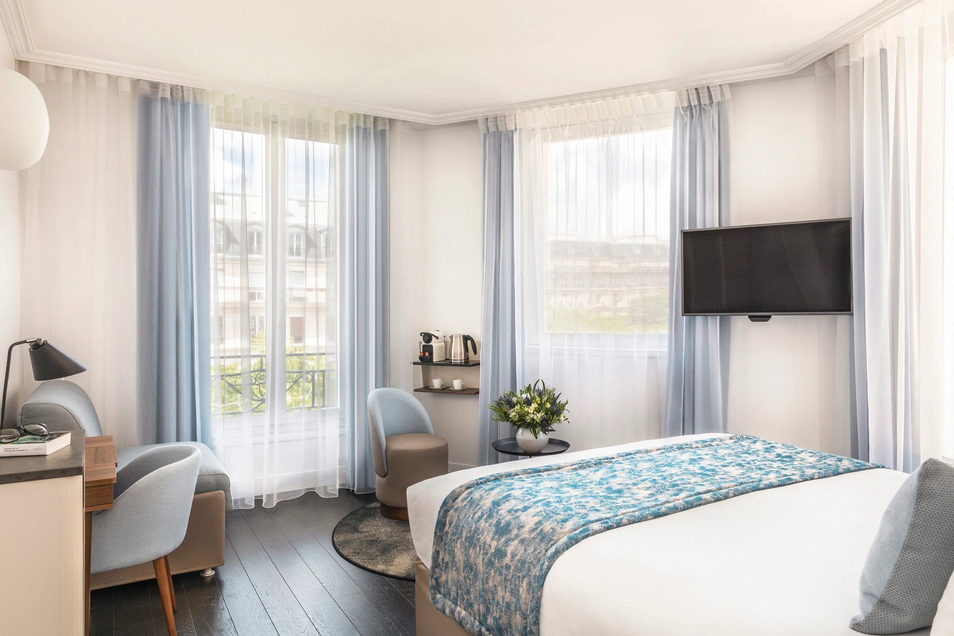 Chambre supérieure triple avec lits et télévision, symbolisant l'hébergement pour plusieurs personnes de BW La Demeure Paris.