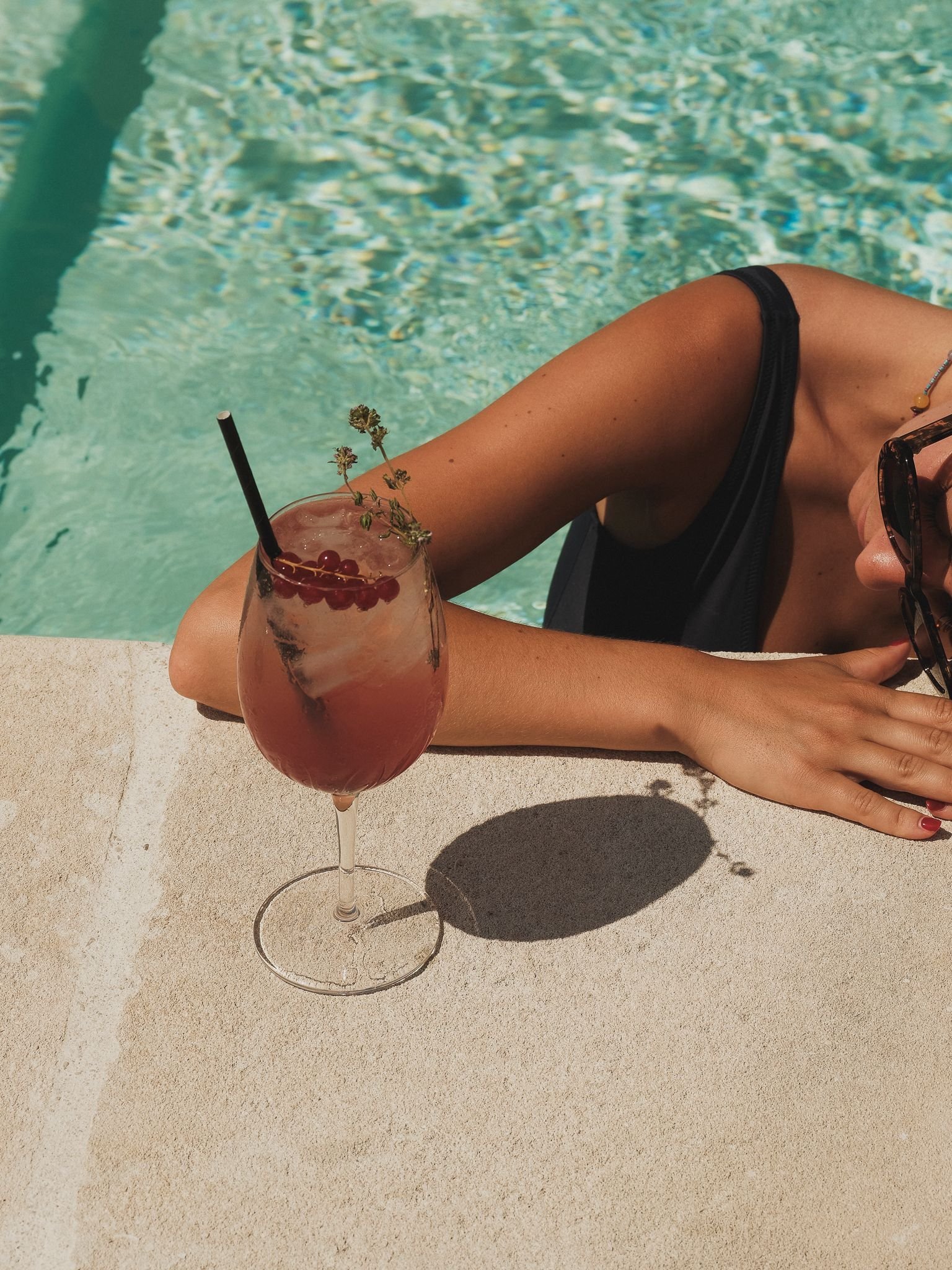 Moment détente au bord de la piscine de la Maison Bérard, cocktail à la main sous le soleil de Provence.