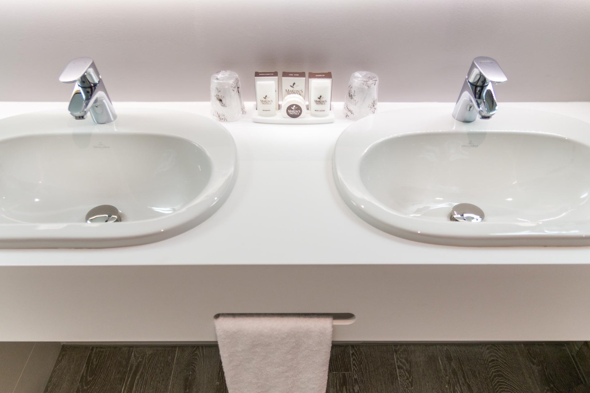 Modern bathroom at Martin's Red with double sink, mirror, and white towels.