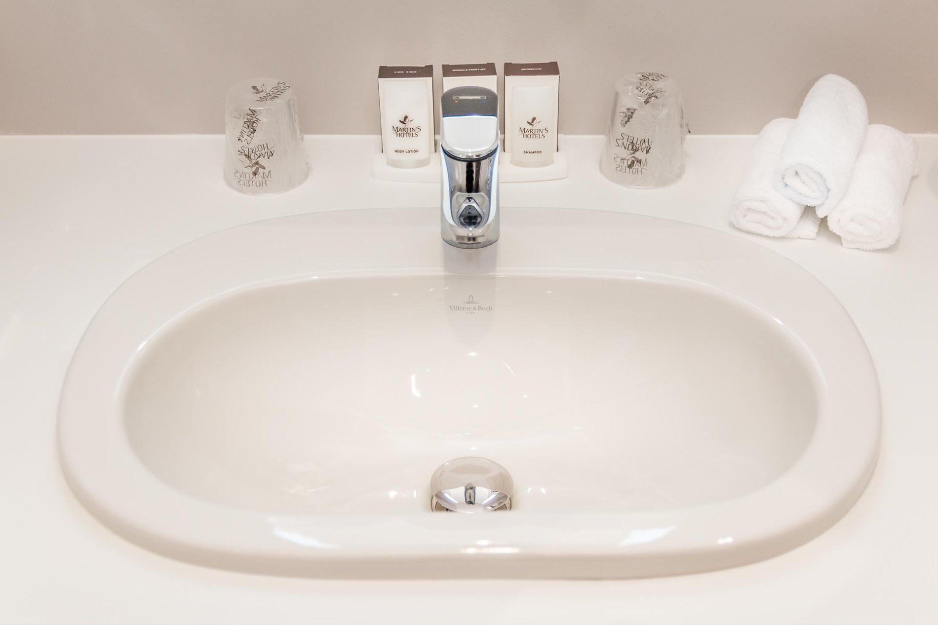 Sink in a bathroom at Martin's Red with toiletries and chrome faucet.