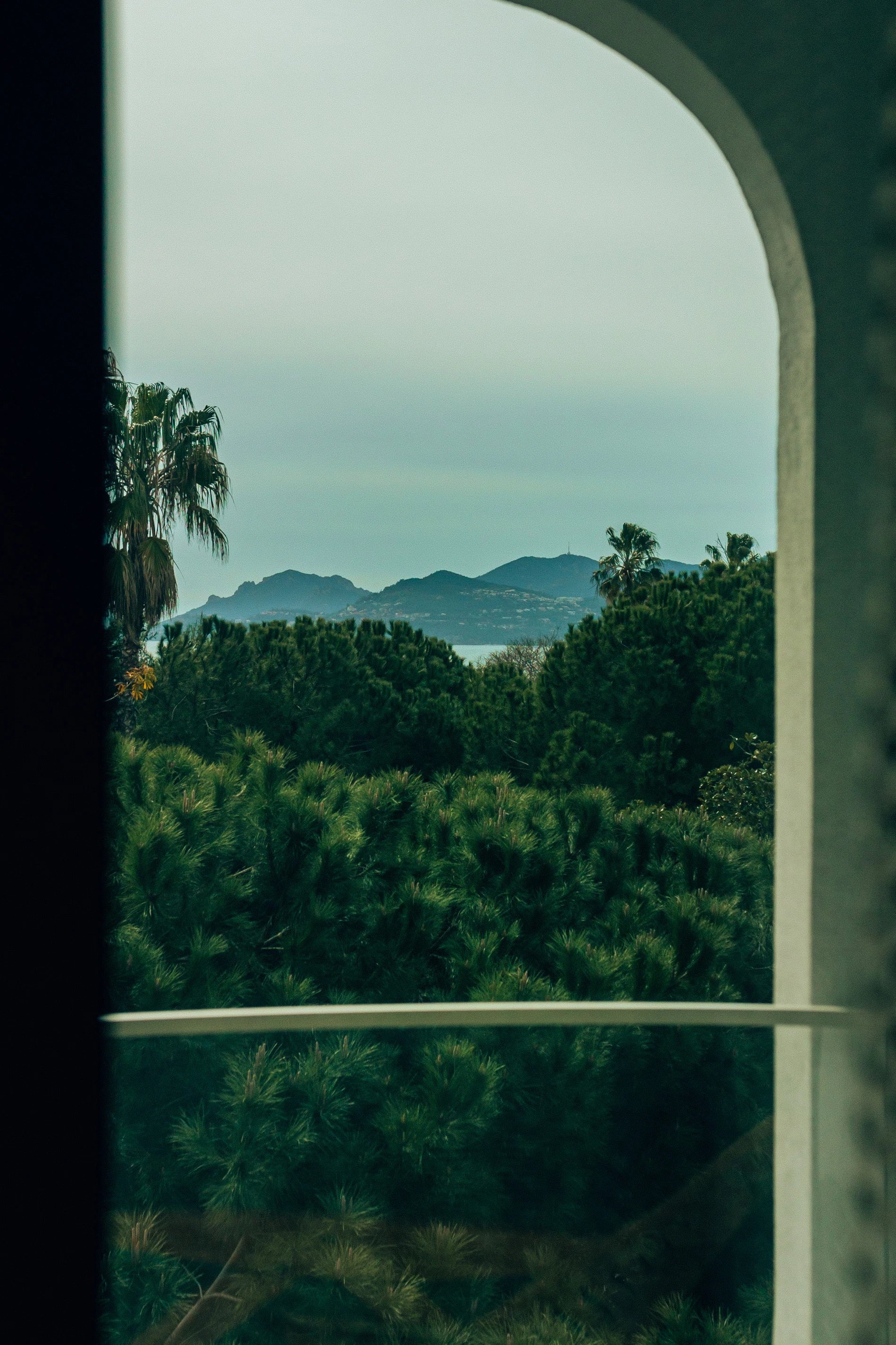 View of Mediterranean greenery and mountains through an archway