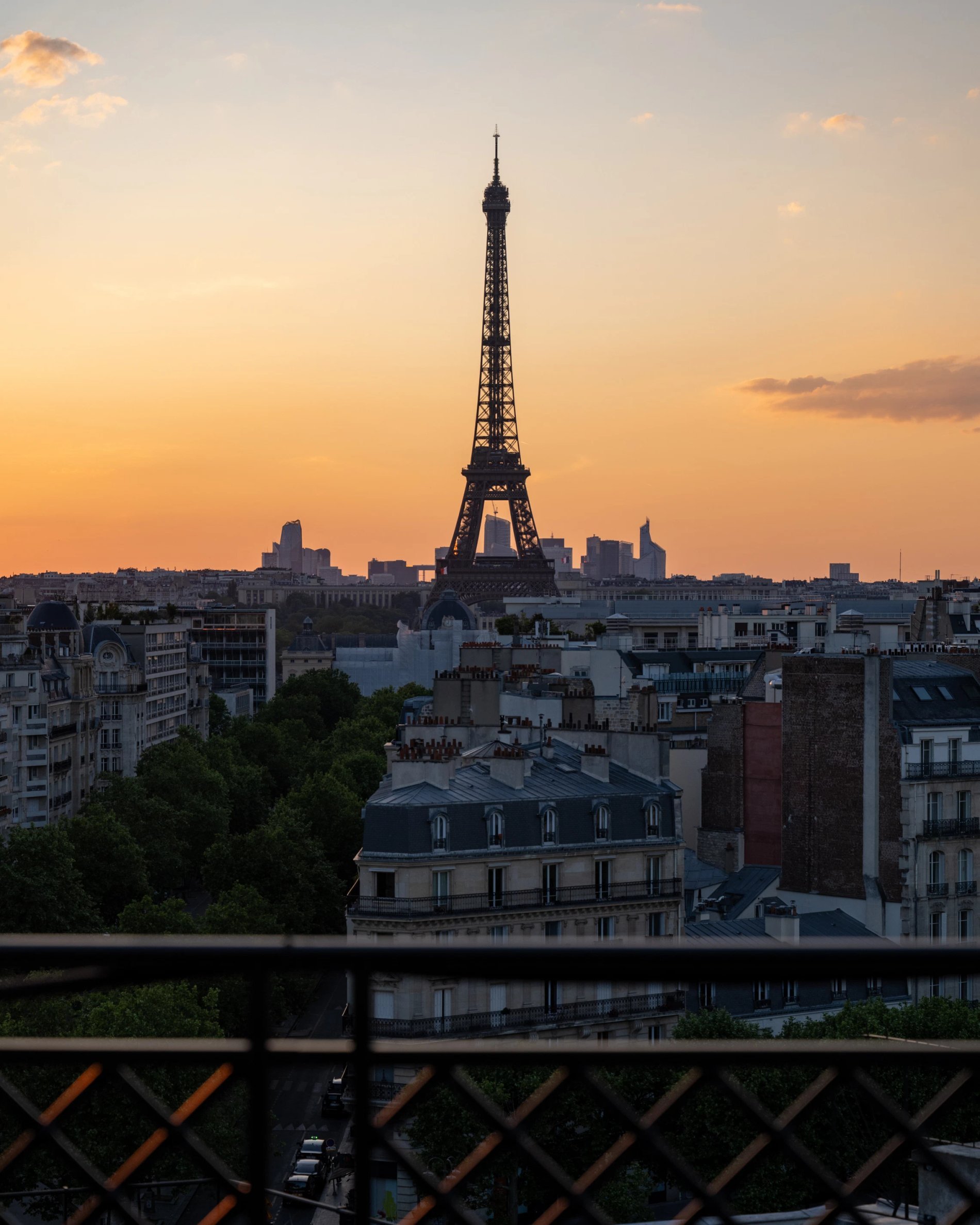 View of the Eiffel Tower at sunset with the urban landscape of Paris in the background