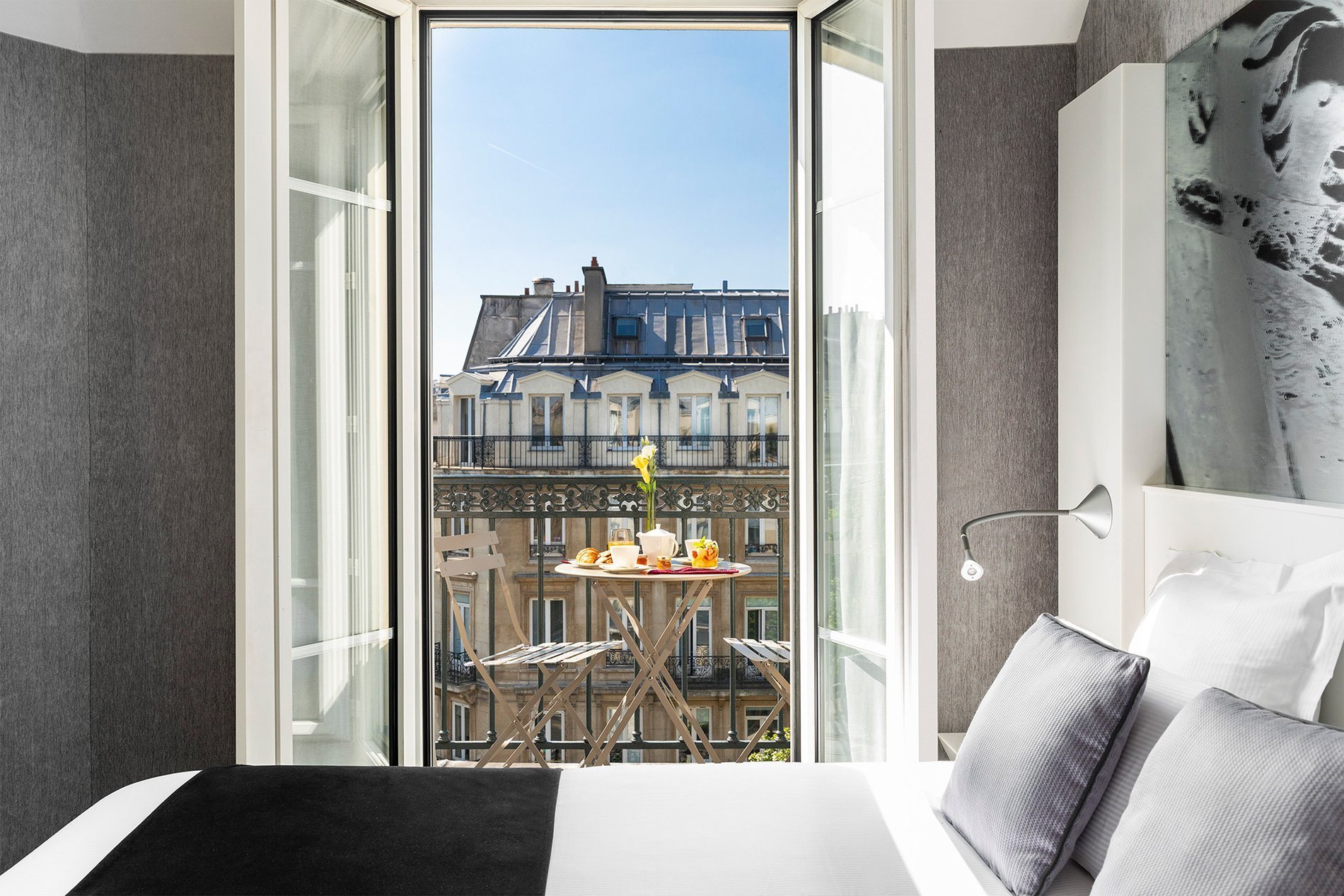 Elegant room with balcony at the Marais Grands Boulevards Hotel in Paris, offering a stunning city view.