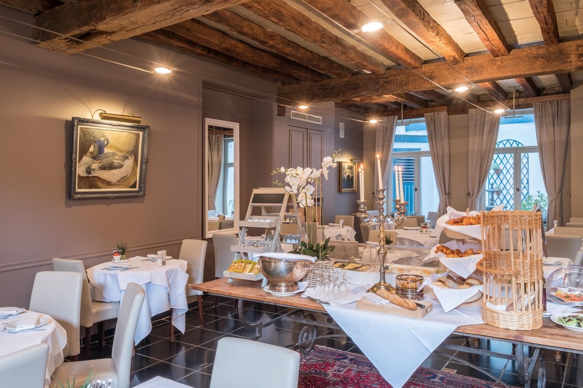 Martin's Relais 4****, Ontbijtruimte met zichtbare balken en uitzicht op de tuin.