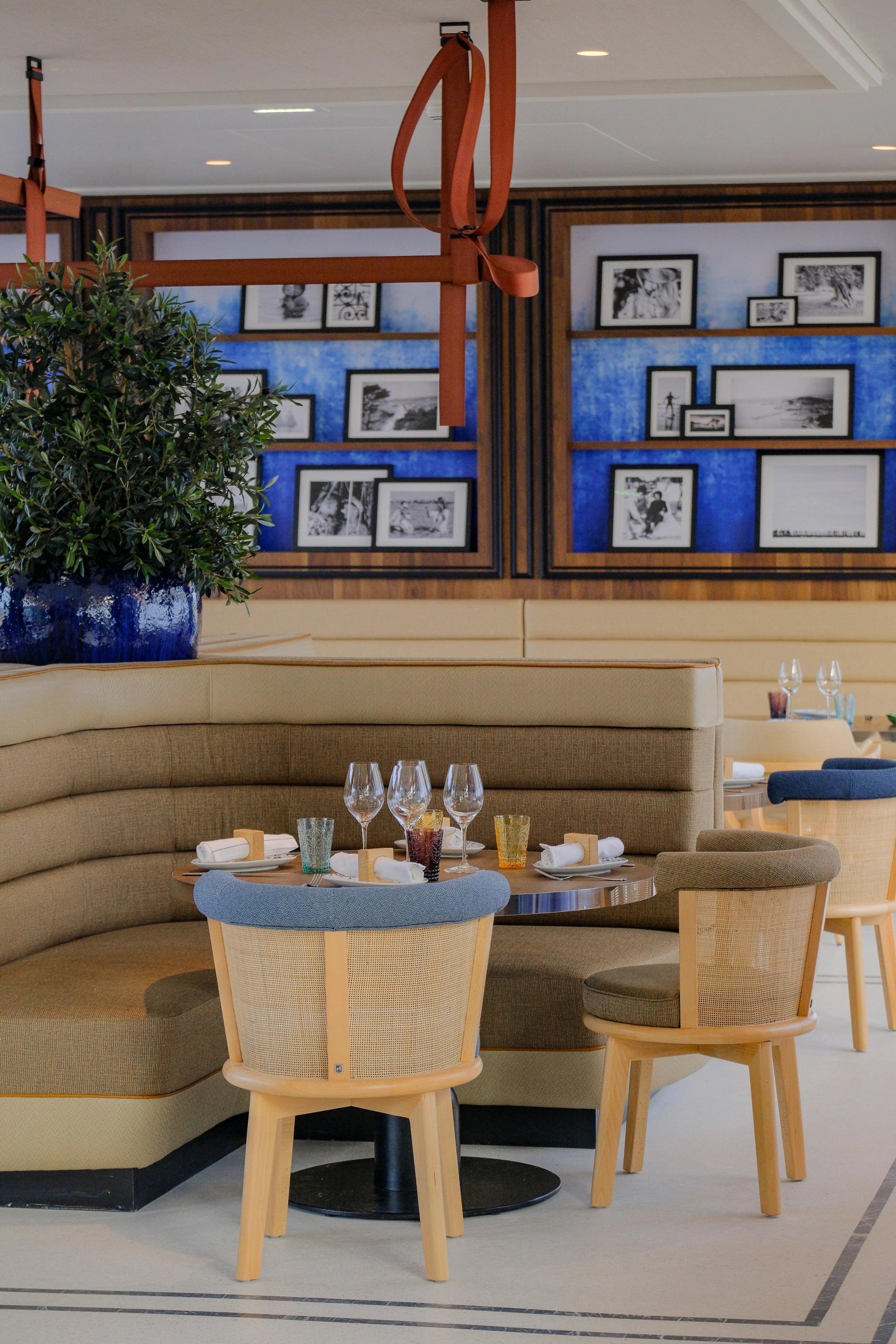 Restaurant bleu roi : tables mises et fauteuils confortables au Bar Taulissa.