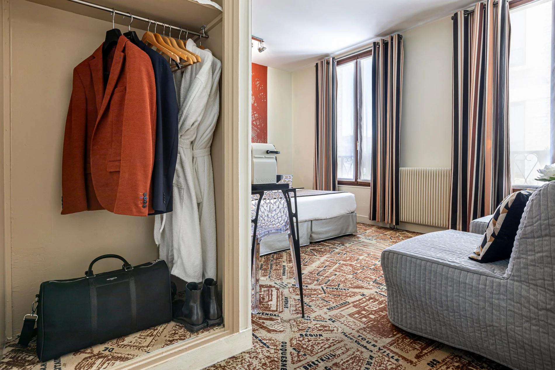 Junior Suite de l'Hôtel Alpha Paris Eiffel avec penderie et espace de rangement.