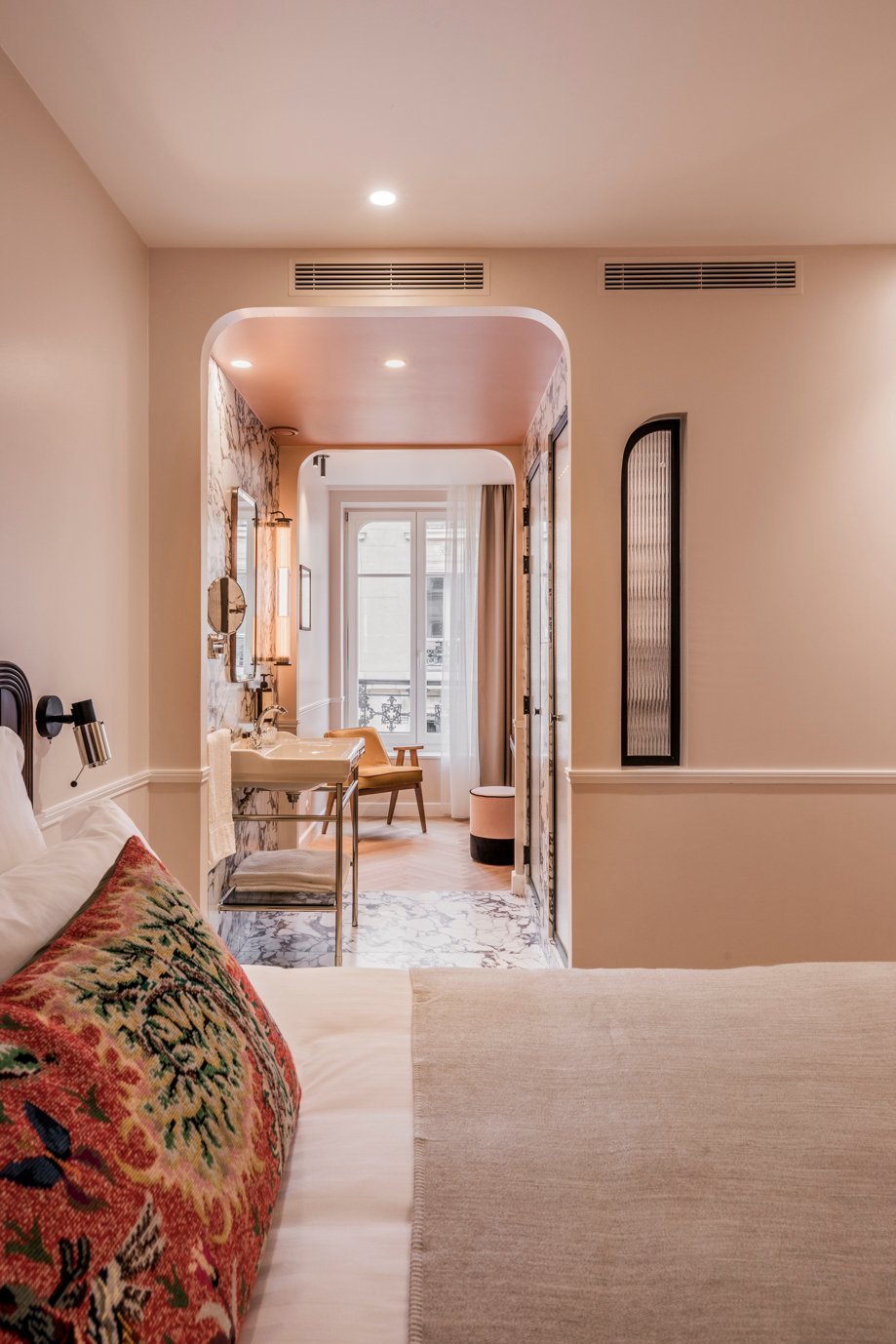 Arched entrance to a guest room at Hotel Chamar, with mirror and soft lighting.