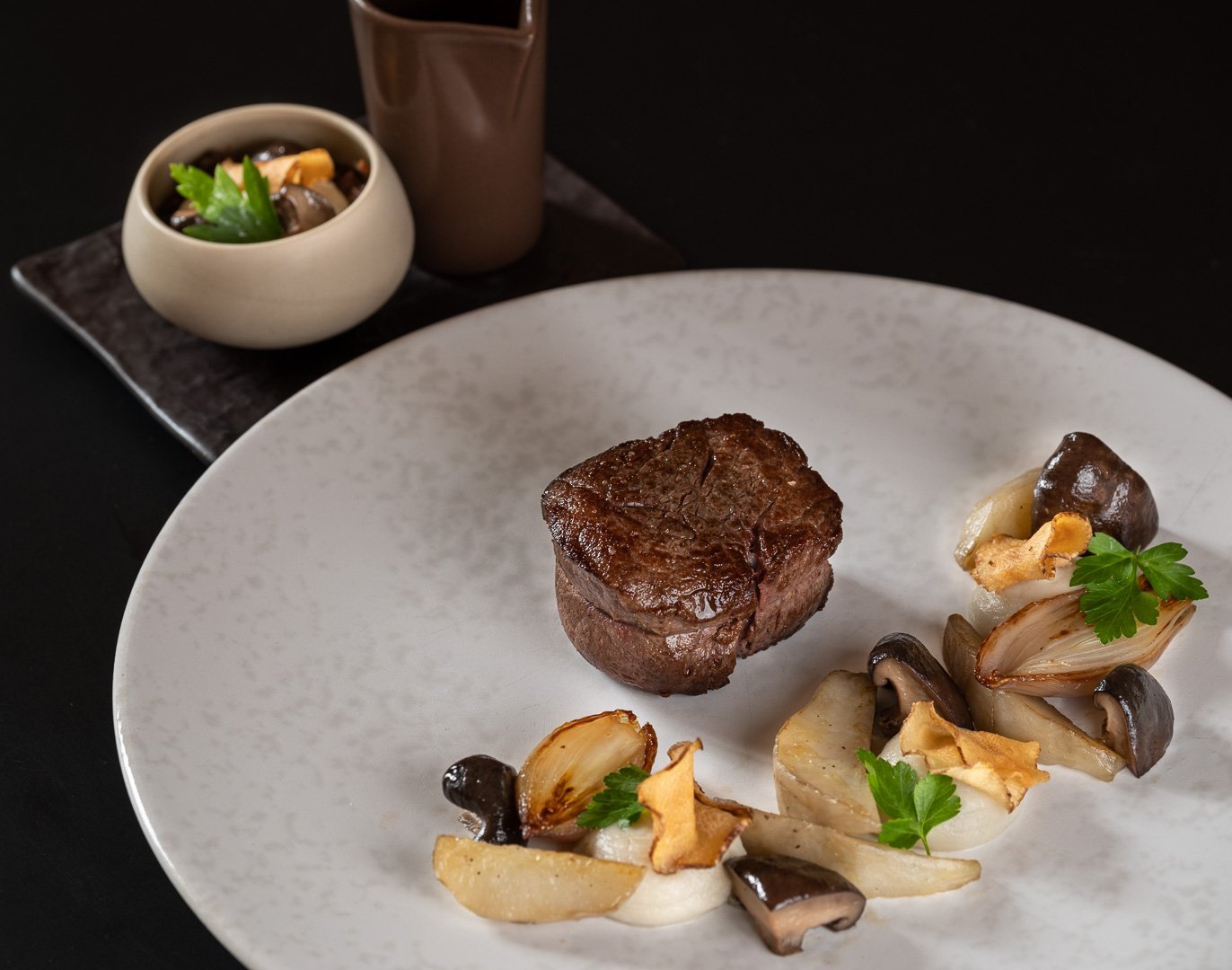 Un plat gastronomique avec un morceau de viande et des champignons, servi à l'Auberge du Bon Laboureur à Chenonceaux.