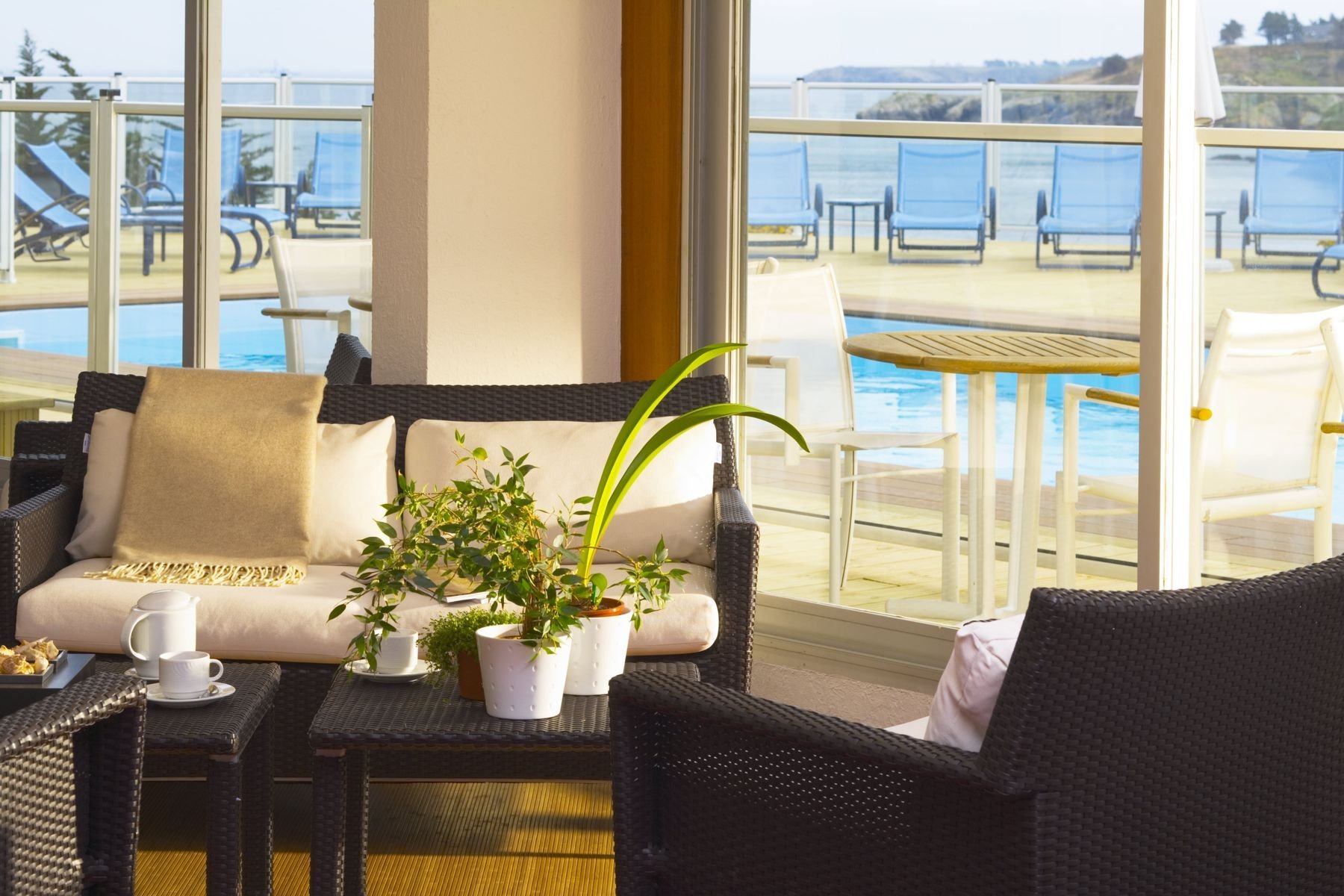 Espace lounge de l’Hôtel Le Cardinal à Belle-Île-en-Mer avec vue sur la piscine extérieure