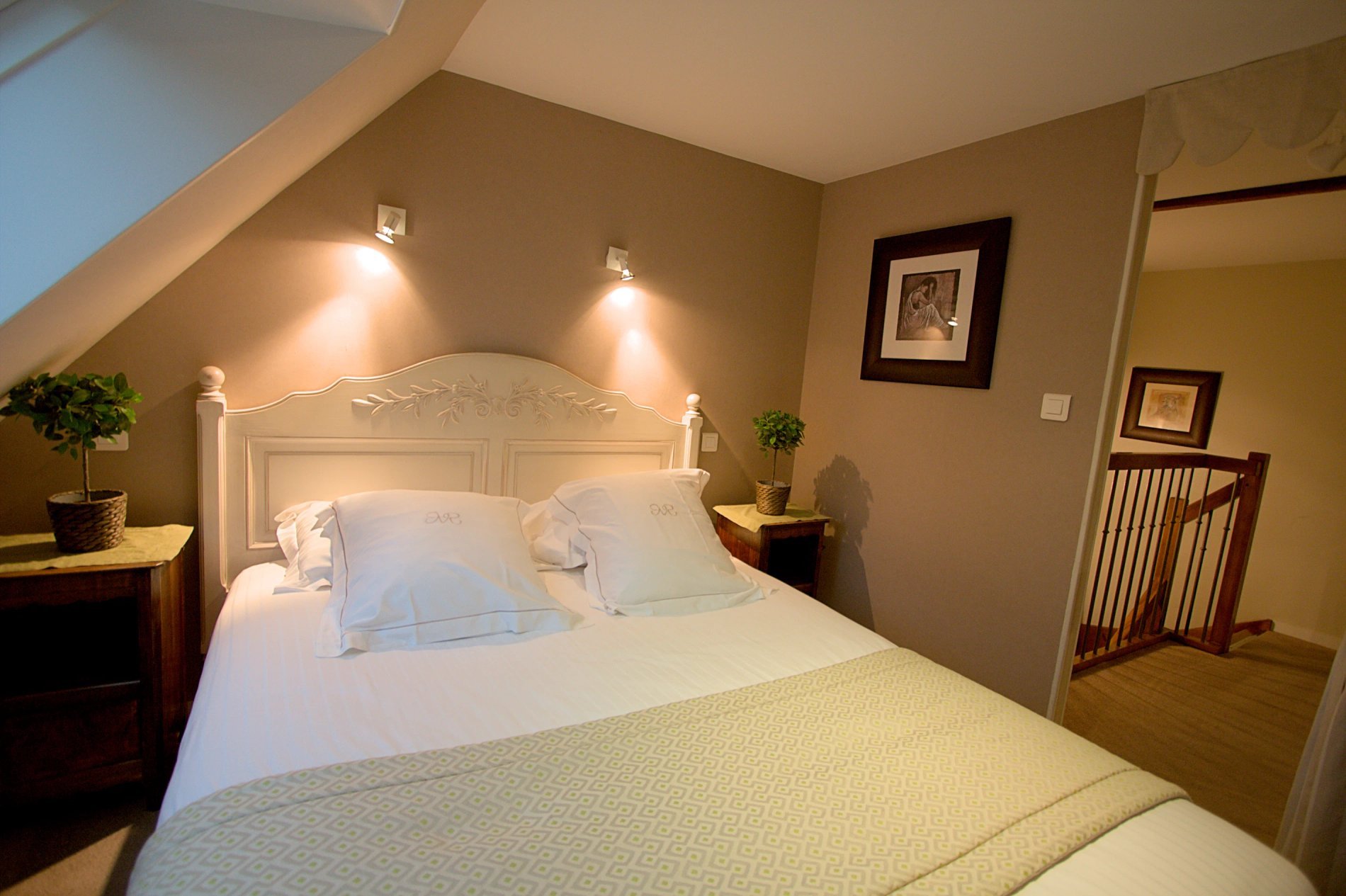 Chambre de la Suite Passiflore de l'Hôtel La Ramade, symbolisant l'espace et le confort de la literie.