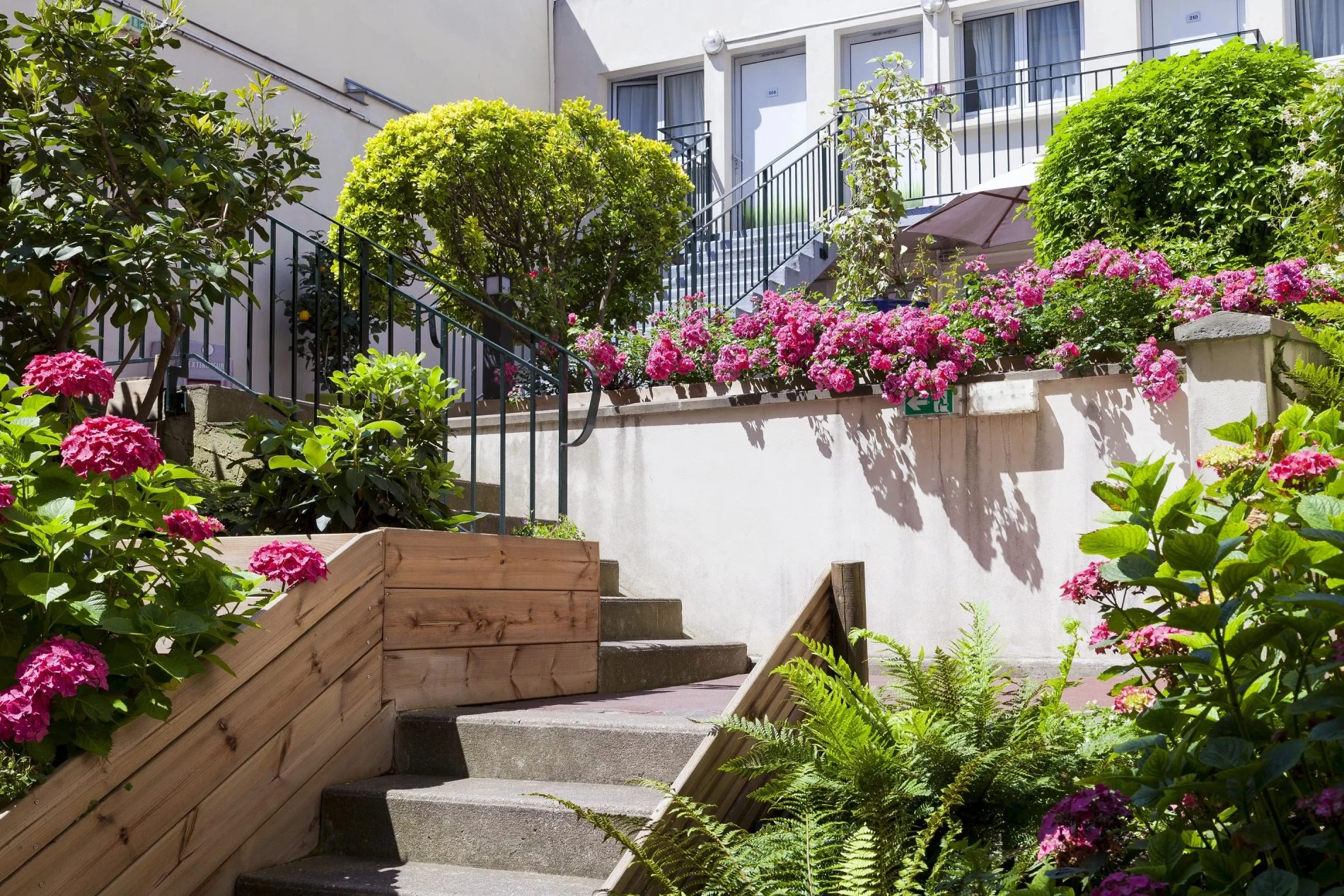 Jardin fleuri avec escalier en pierre au Timhotel Nation