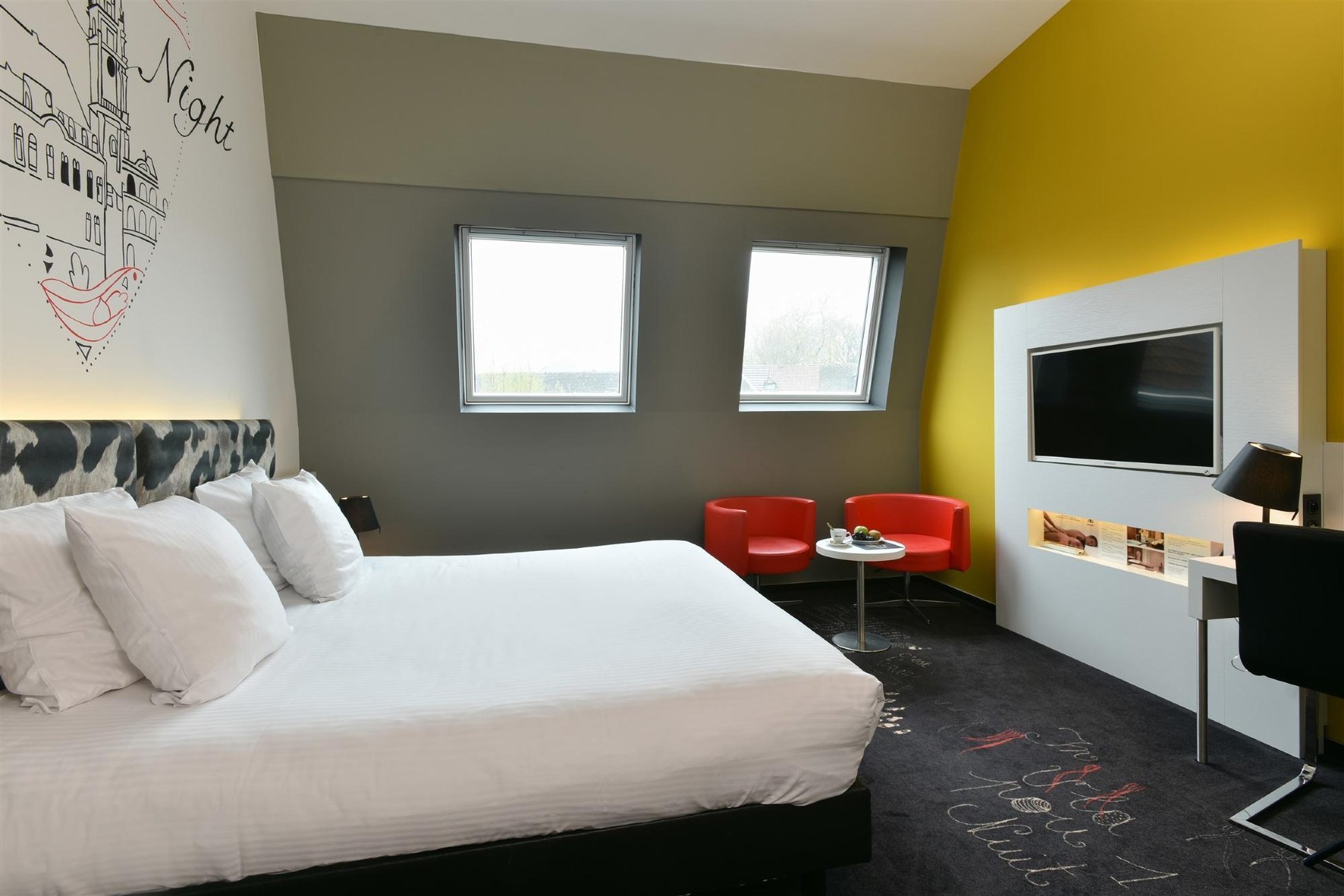 Gemütliches Plus-Zimmer mit Sitzecke und Schreibtisch.