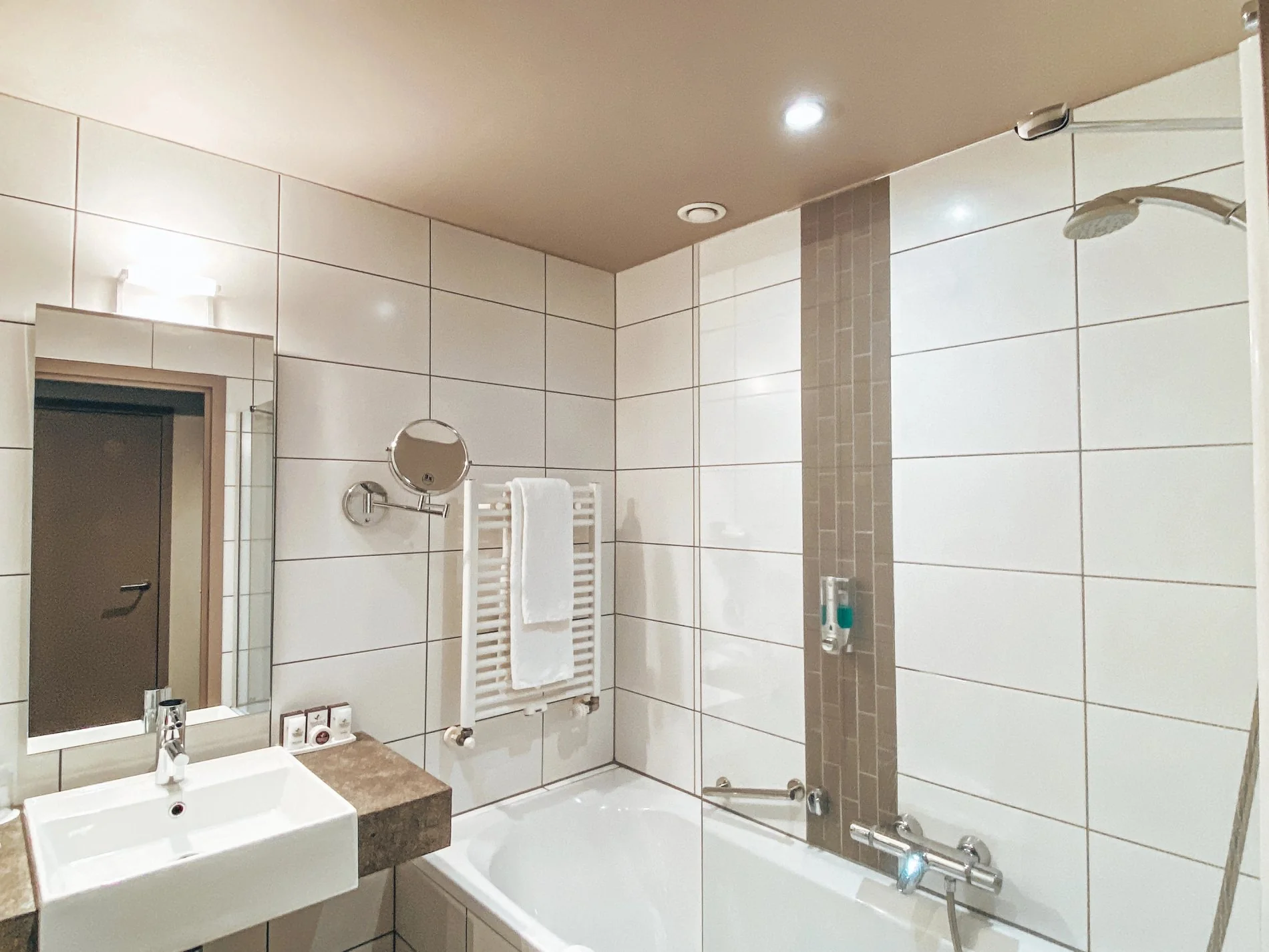 Salle de bain moderne avec baignoire et douche au Martin's Klooster à Louvain.