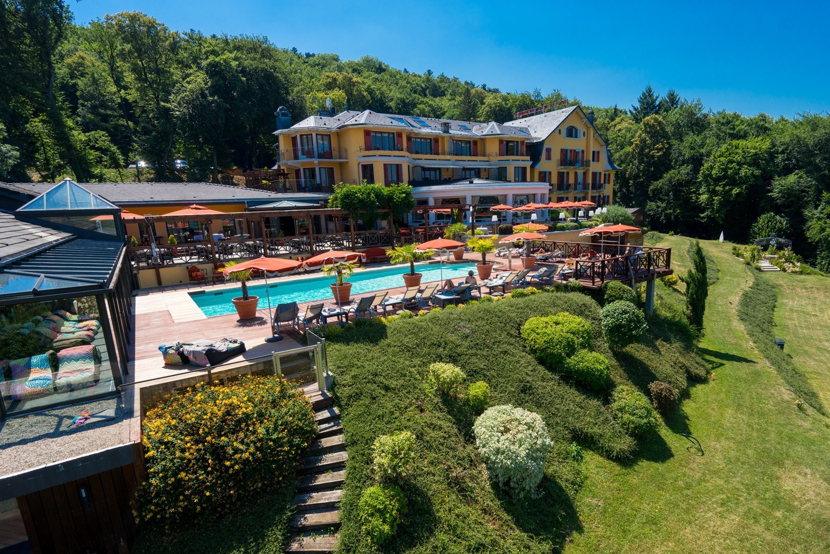 View of Hôtel Les Trésoms Lake & Spa Resort, a charming 4-star hotel with outdoor pool, spa and restaurants, nestled between lake and mountains in Annecy.