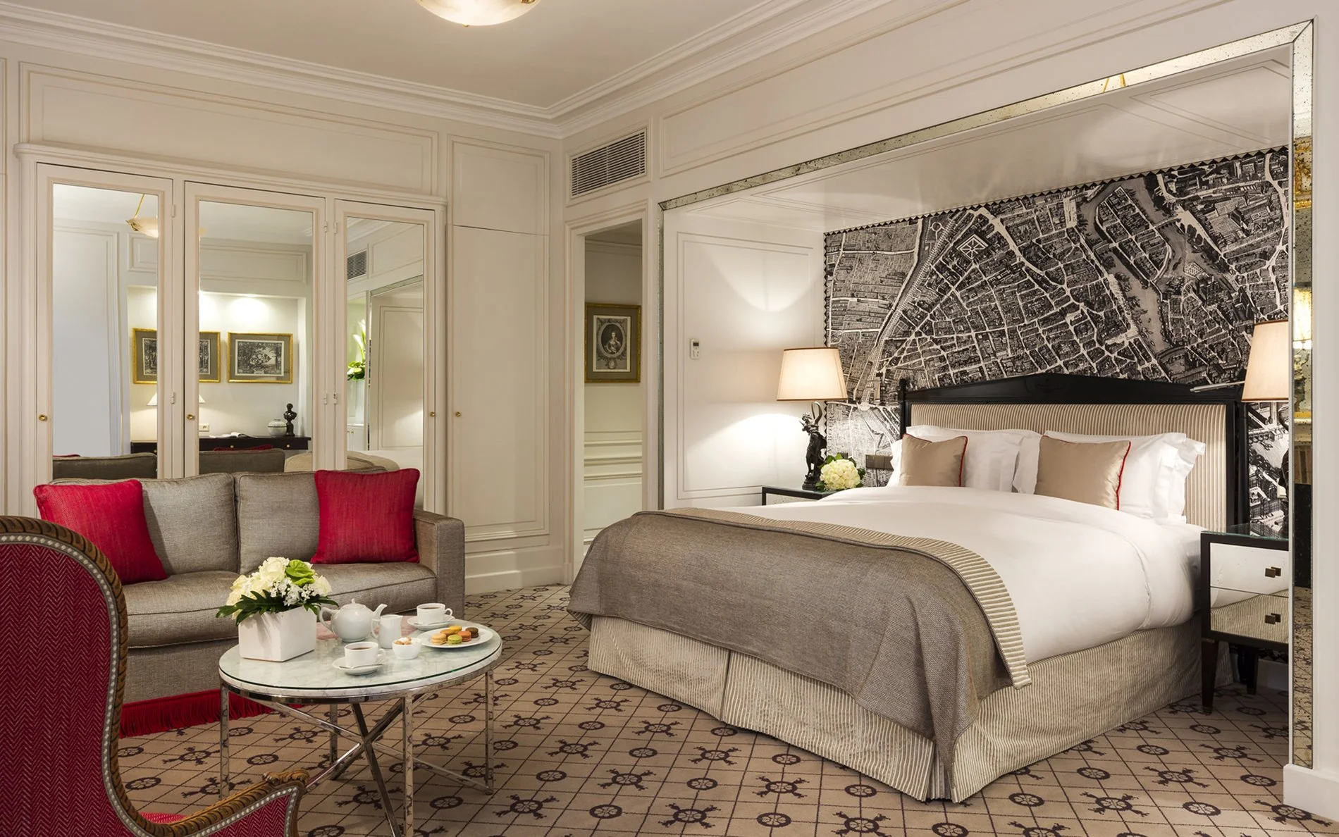 Room at Hôtel San Régis in Paris featuring a vintage Paris map wall, sofa, coffee table and warm atmosphere.