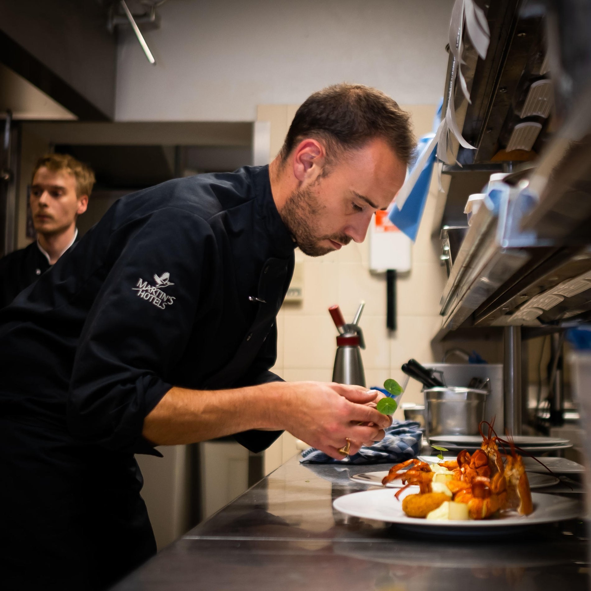 Chef preparing a gourmet dish in a professional kitchen.