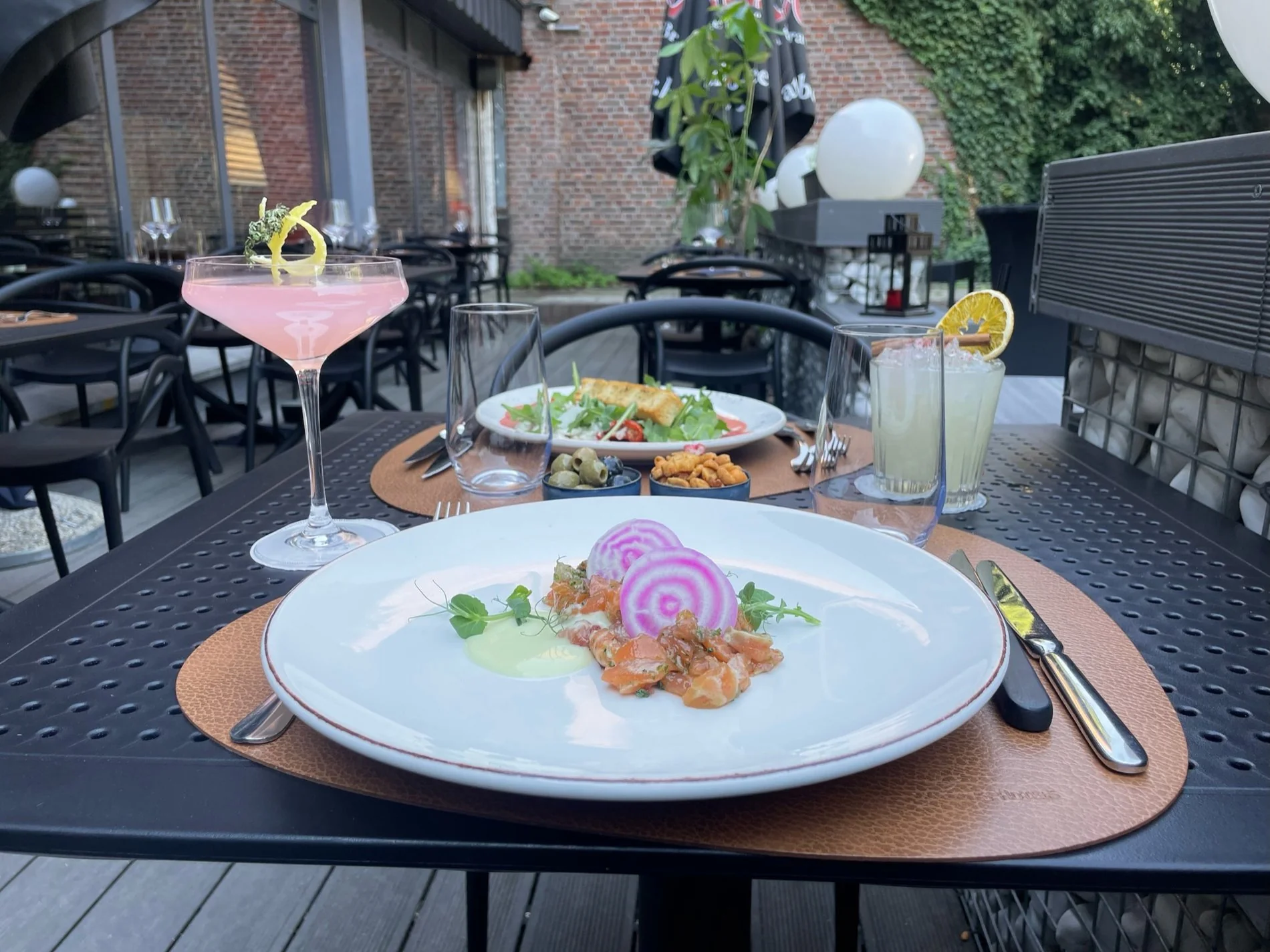 Plat gastronomique servi en terrasse au Martin's Dream, avec vue sur le jardin.