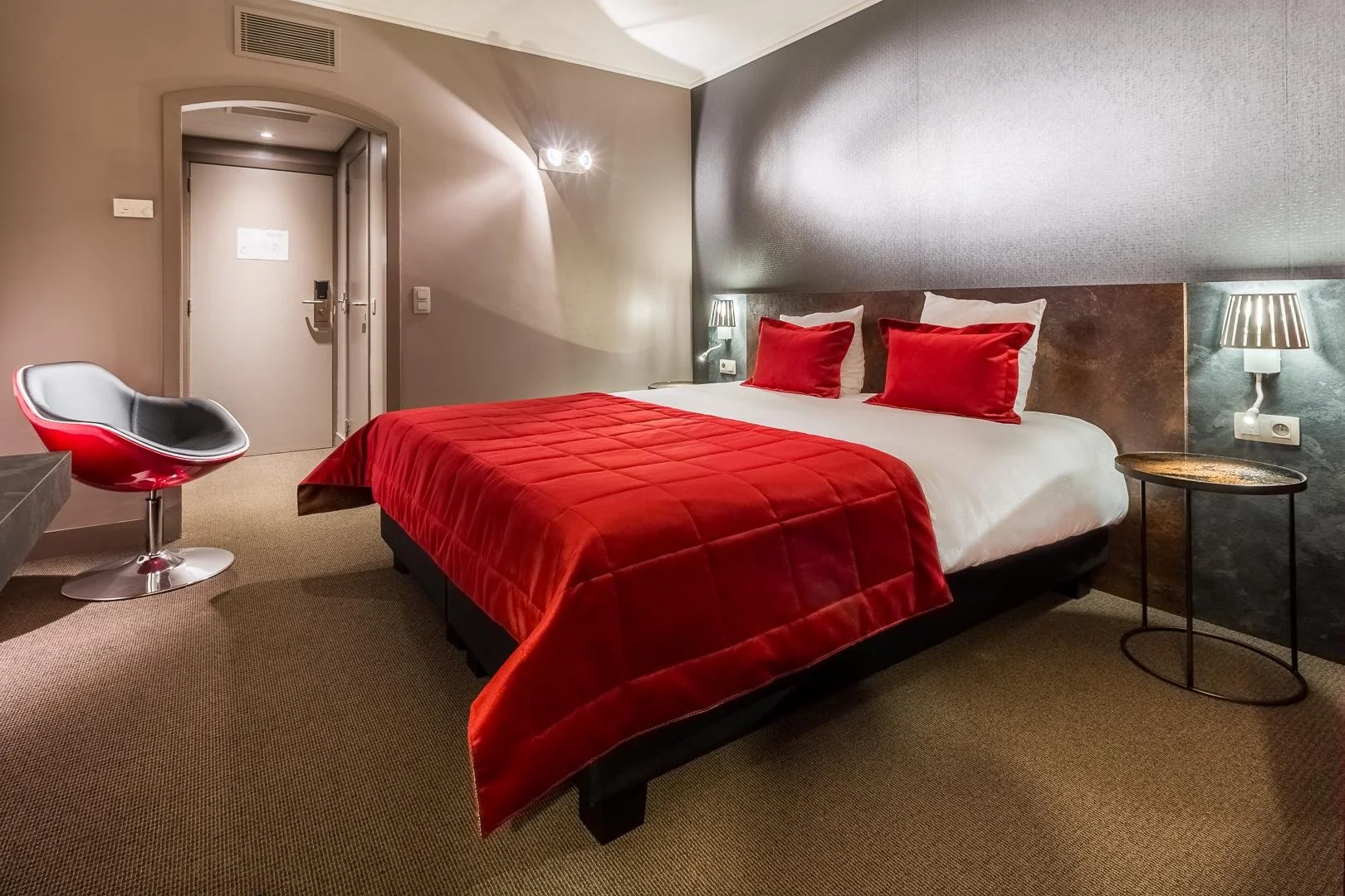 Zimmer mit rotem Doppelbett und Designerstuhl, zeitgenössische Atmosphäre