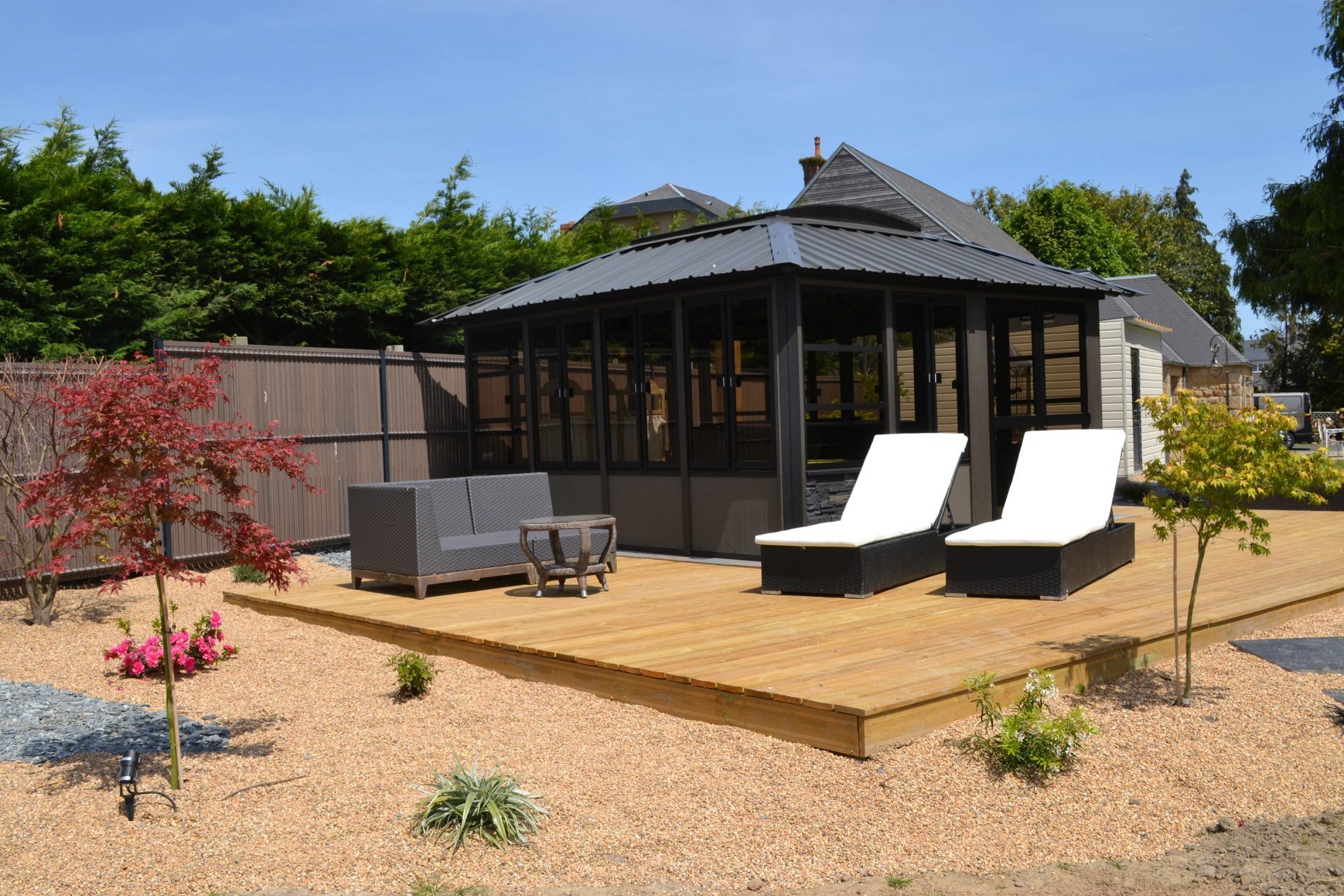 Espace de détente extérieur de l'Hôtel La Ramade avec transats, symbolisant le repos et le farniente.