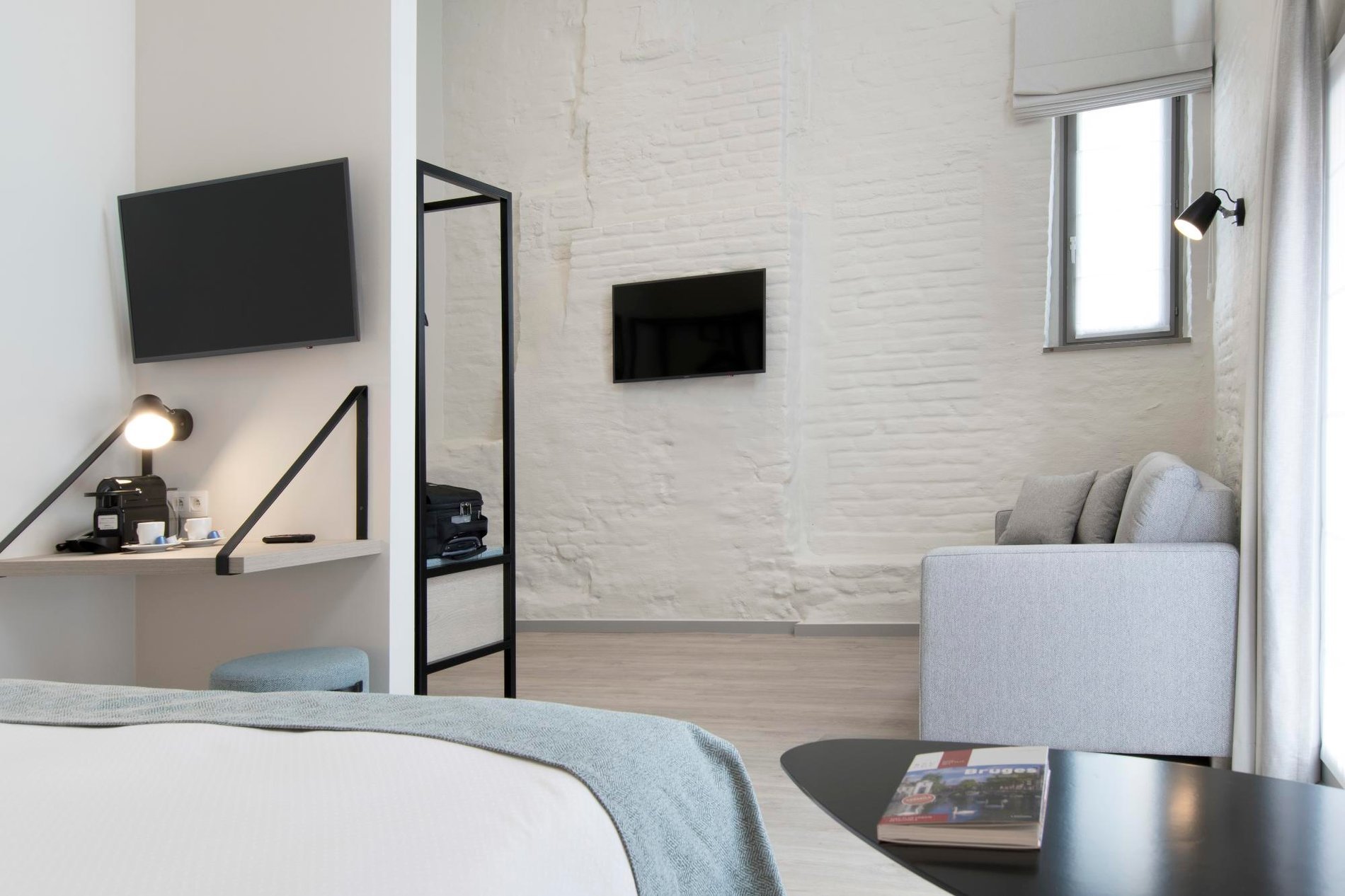 Eleganter Sitzbereich mit Fernseher und zeitgemäßen Möbeln im Martin's Brugge