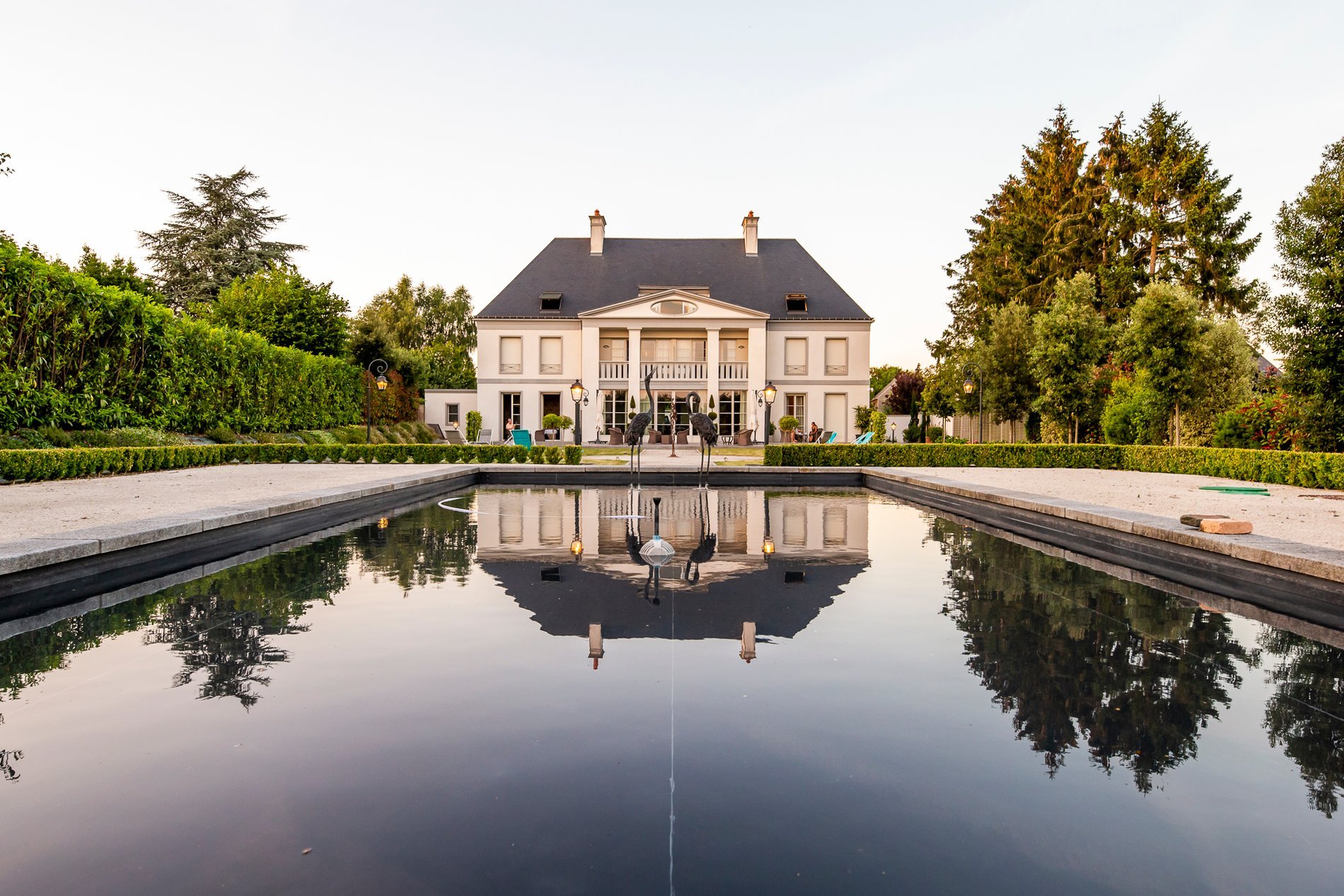 Panoramic view of Hotel La Ramade and its basin, symbolizing the expanse and splendor of the grounds.