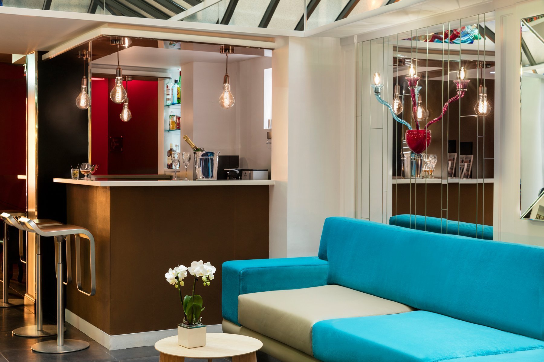 Espace bar lounge moderne avec canapé coloré et éclairage design – Hôtel Louvre Saint-Honoré, Paris 1er