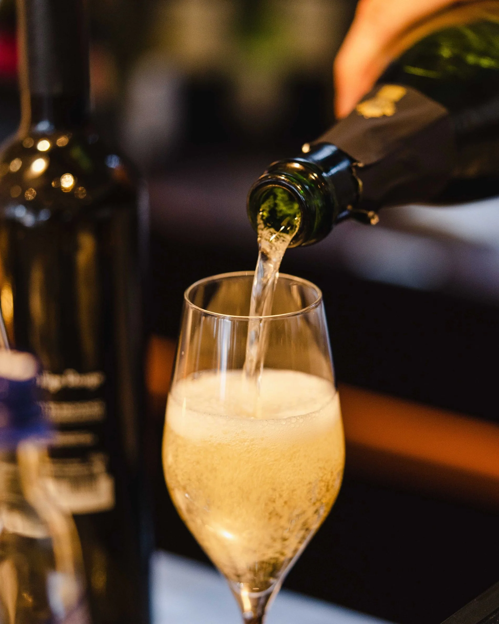 Champagne versé dans une flûte élégante au bar du Martin's Château du Lac.