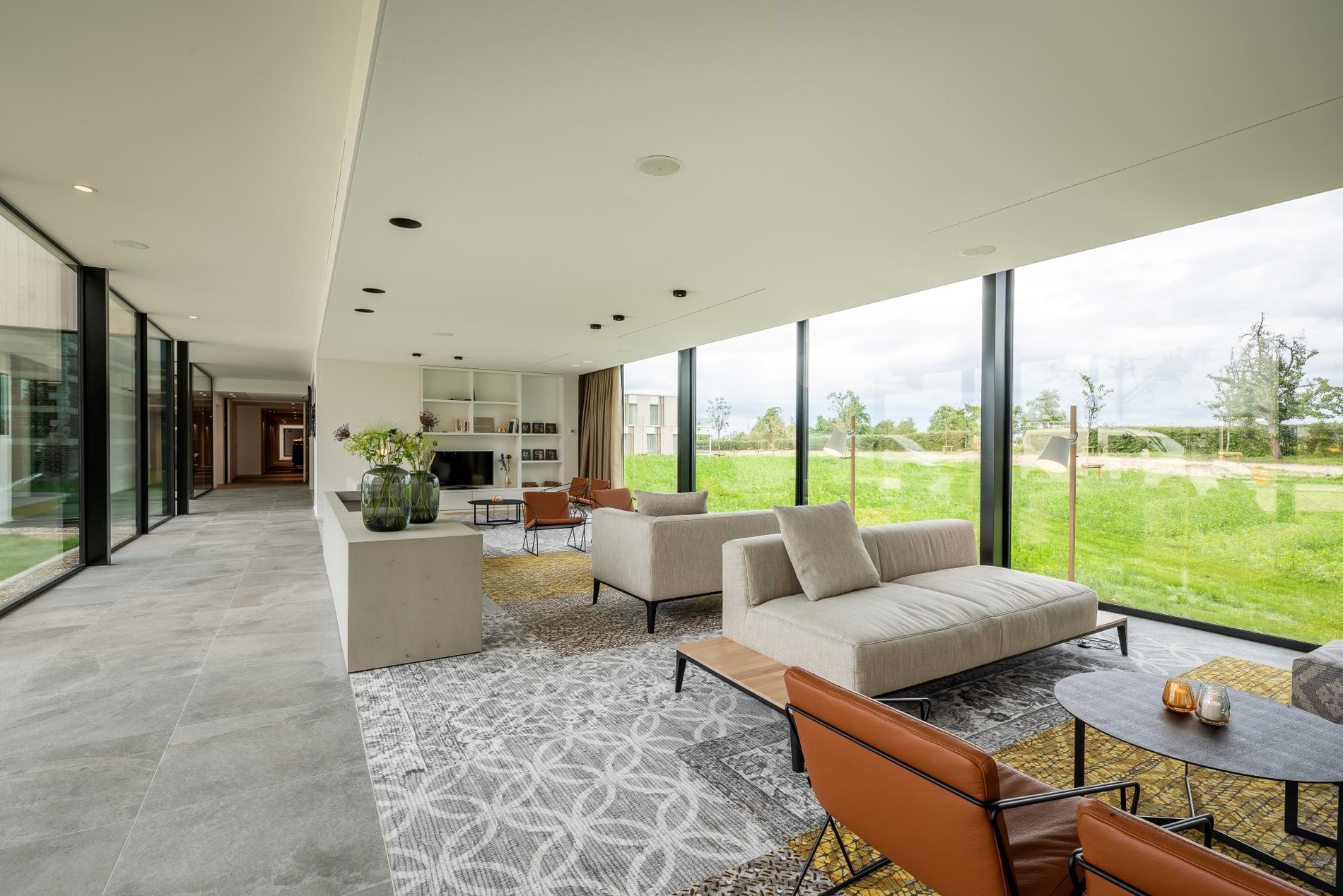 Bright and modern lounge with outdoor views at Martin's Rentmeesterij in Bilzen.