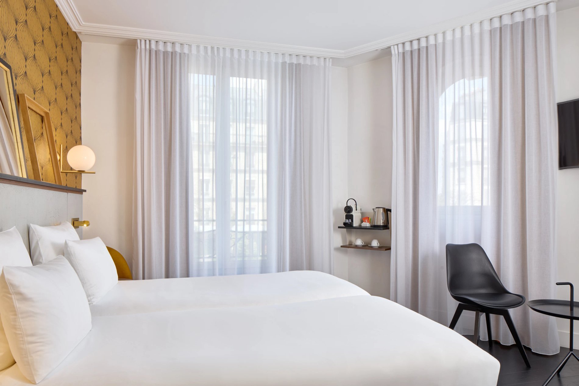 Chambre double classique avec lits et décoration lumineuse, symbolisant l'hébergement confortable de BW La Demeure Paris.