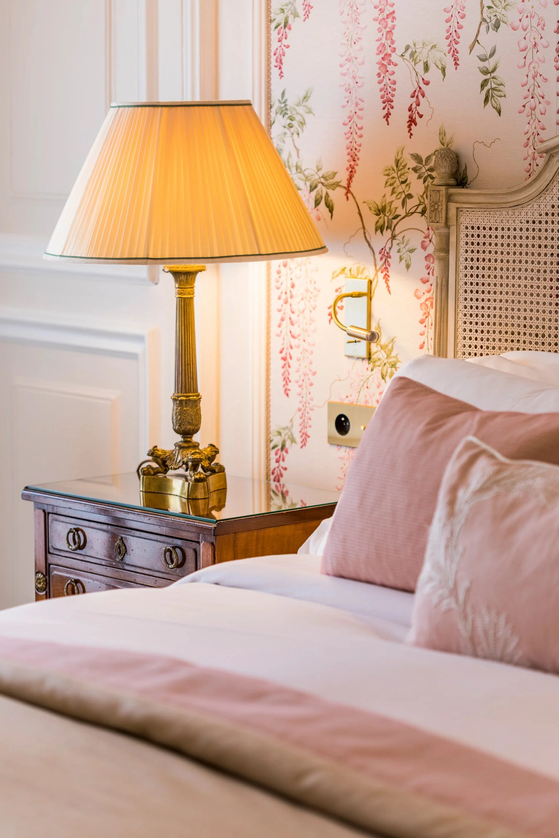 Détail de lampe et coussins dans une chambre deluxe de l’Hôtel San Régis, atmosphère douce et cosy.
