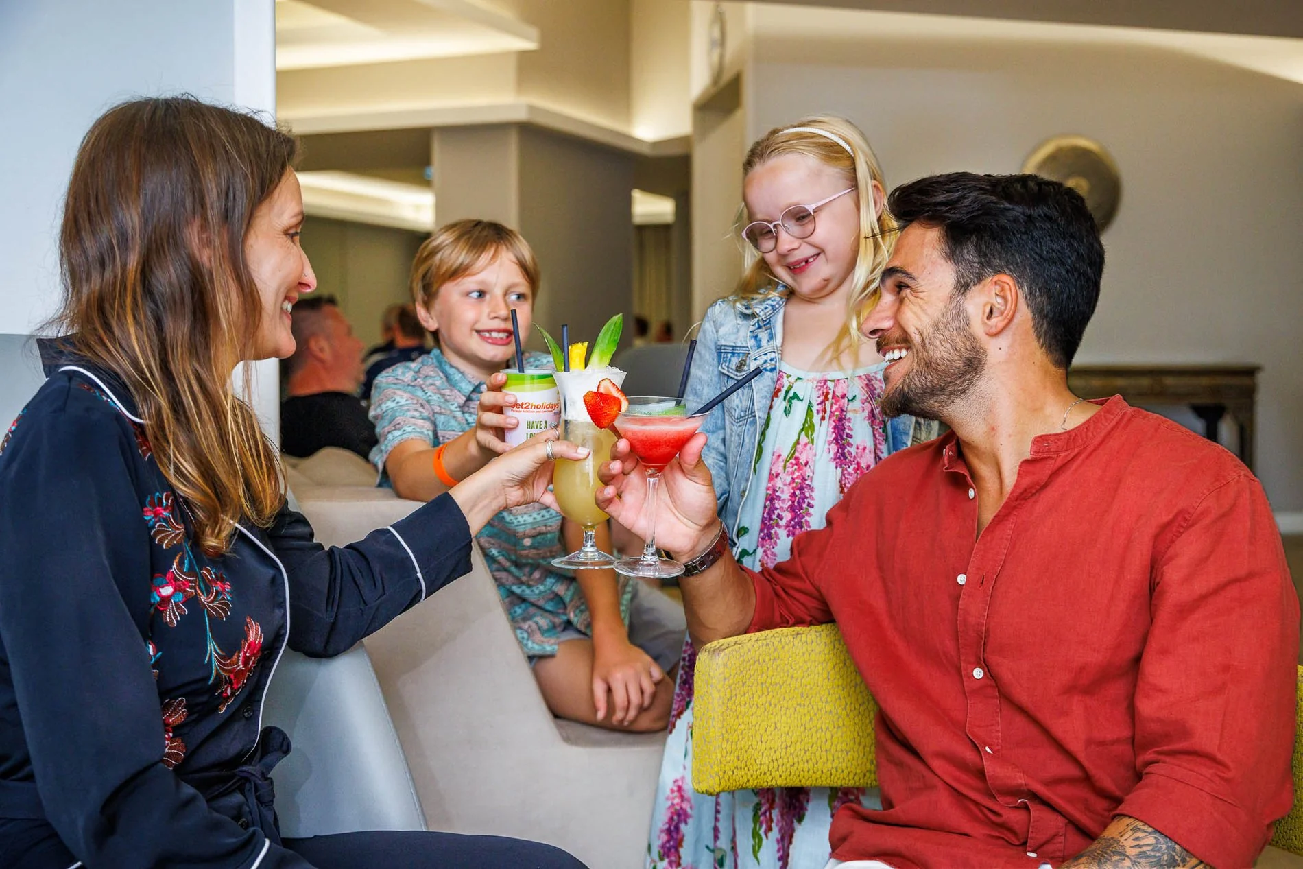 Famille heureuse trinquant avec de délicieuses boissons au Al Bar de l’Hôtel Jupiter Albufeira