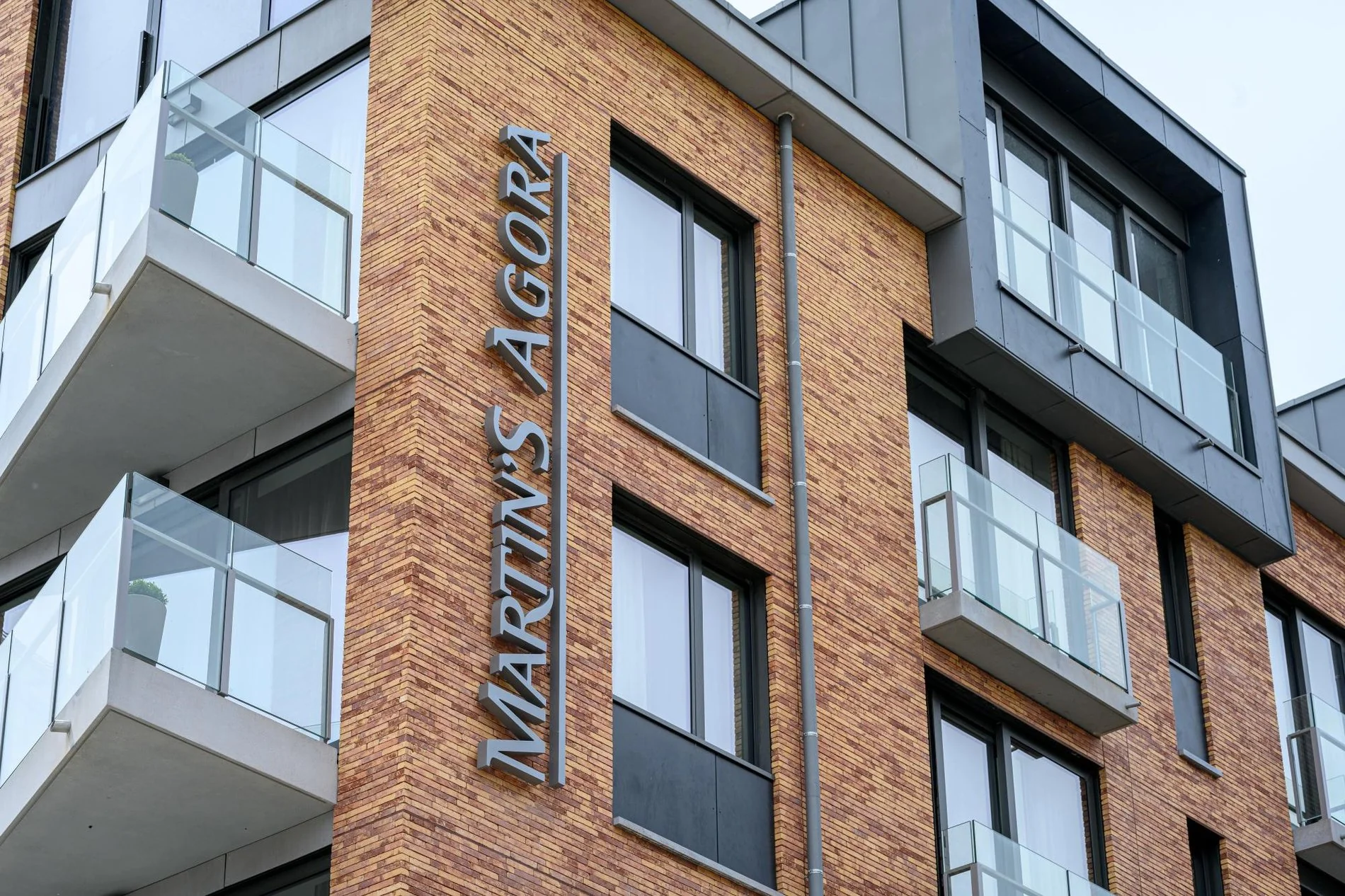 Façade en briques avec balcons et enseigne de l’hôtel Martin's Agora.