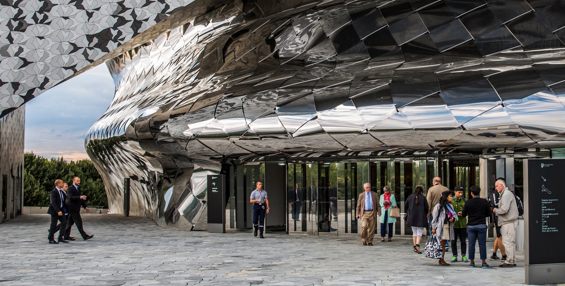 Entrance of the Philharmonie de Paris with visitors in front.