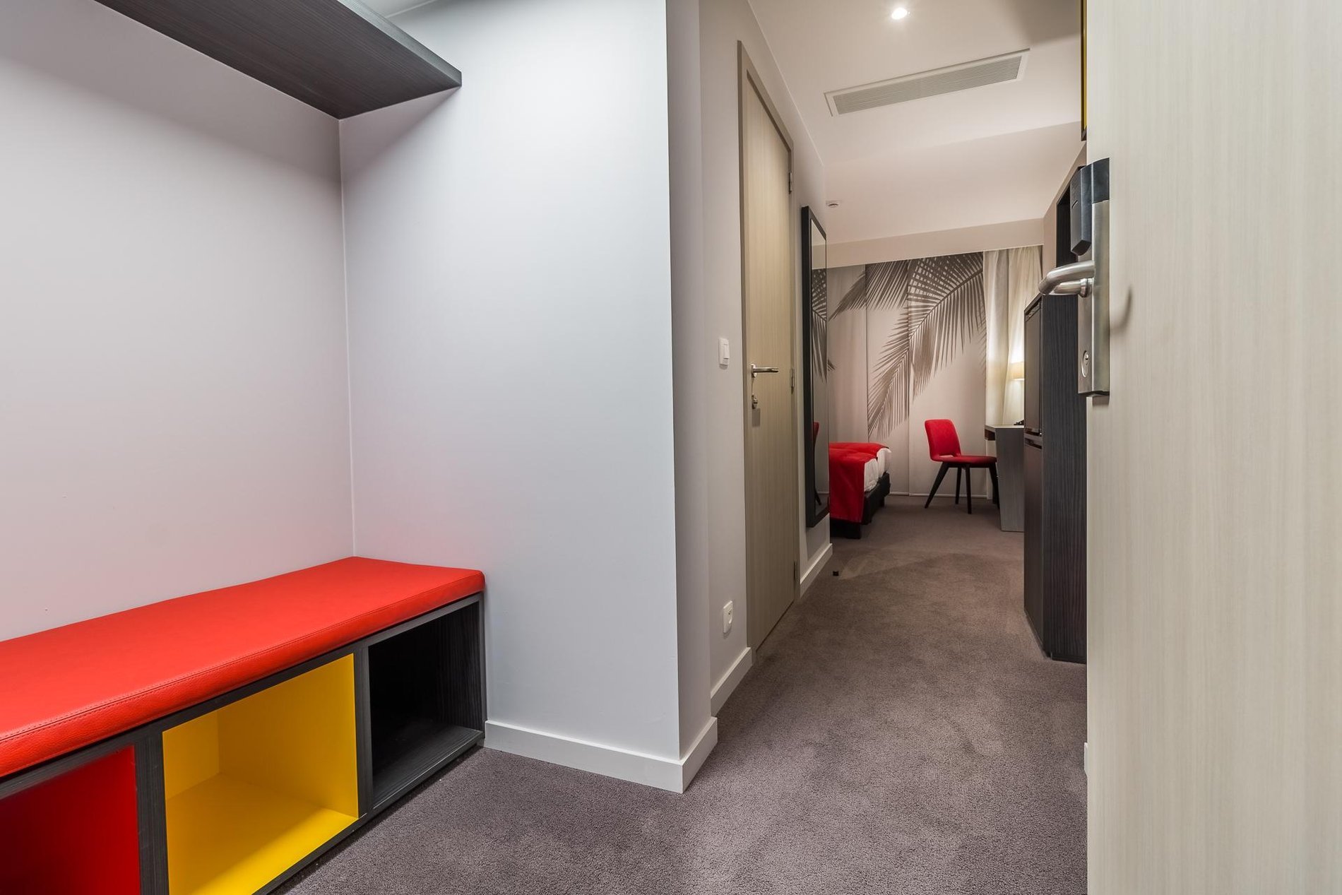 Entrance of a room at Martin's Red with a red bench and a bright hallway.