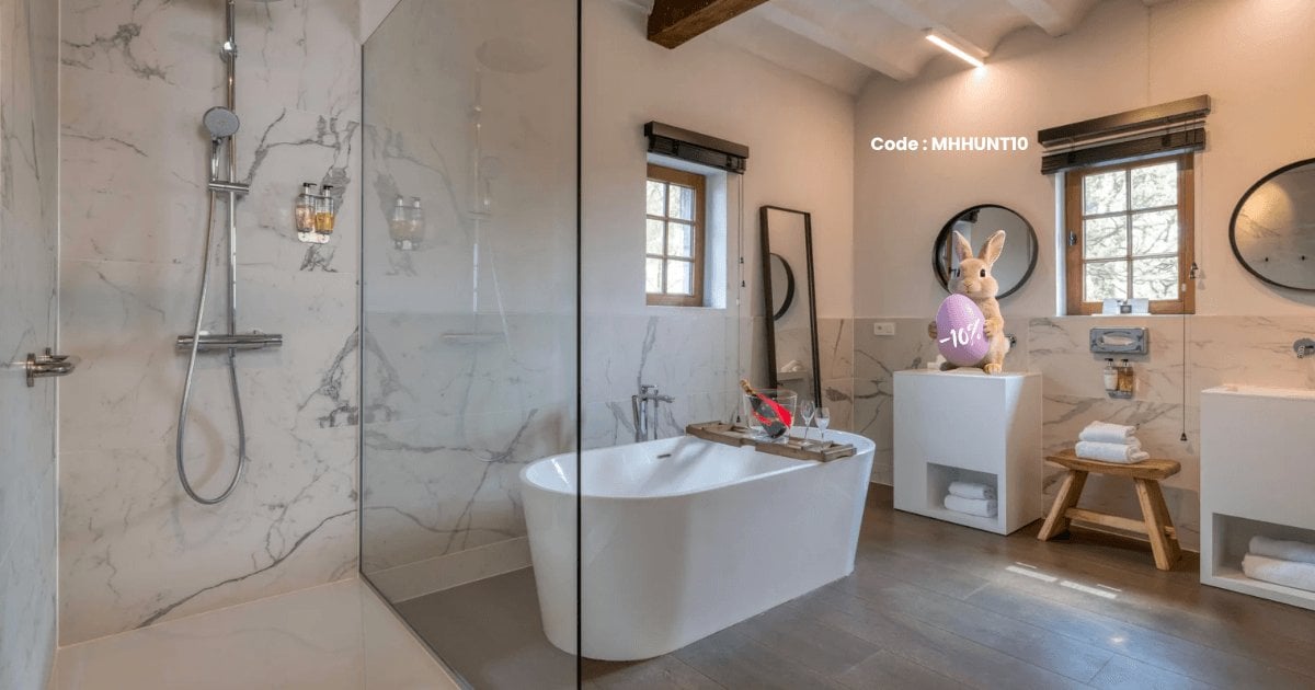 Bright bathroom with bathtub and shower in the suite at Martin's Rentmeesterij, Bilzen.