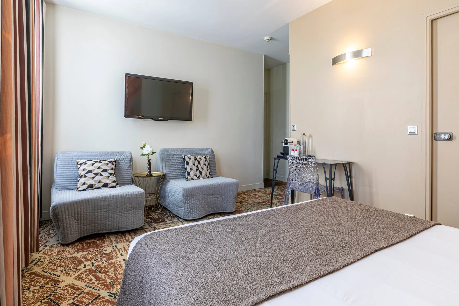 Junior Suite de l'Hôtel Alpha Paris Eiffel à Boulogne-Billancourt avec espace détente.