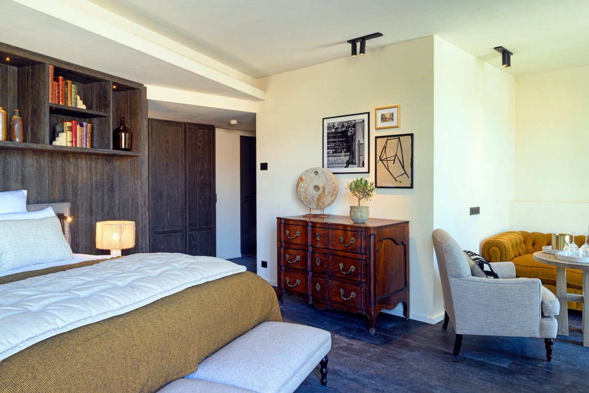 Isle de Leos, Vue d’ensemble d’une chambre lumineuse avec canapé et coin bureau à L’Isle de Leos.