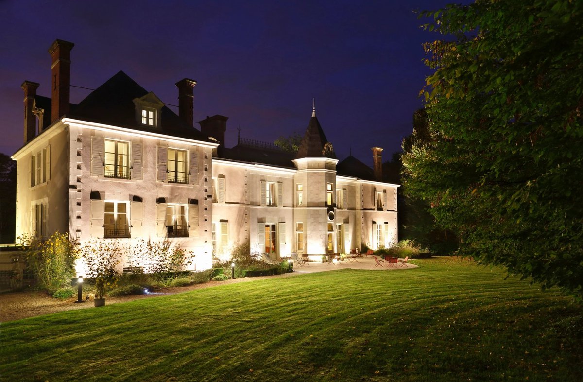 Château de la Rozelle, Façade éclairée d'un hôtel de style classique avec jardin la nuit