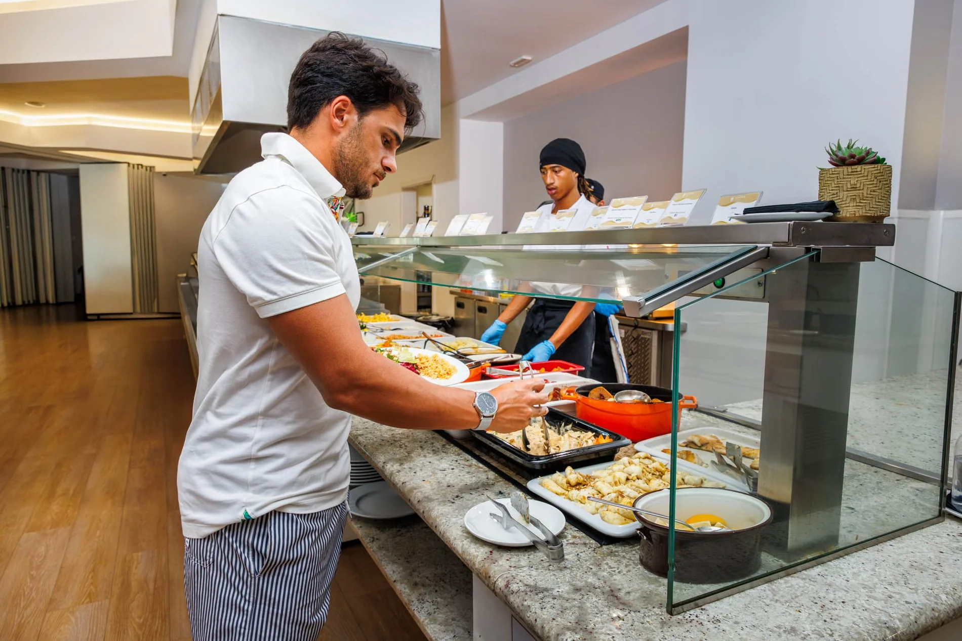 Homme se servant au buffet du petit-déjeuner de l’Hôtel Jupiter Albufeira