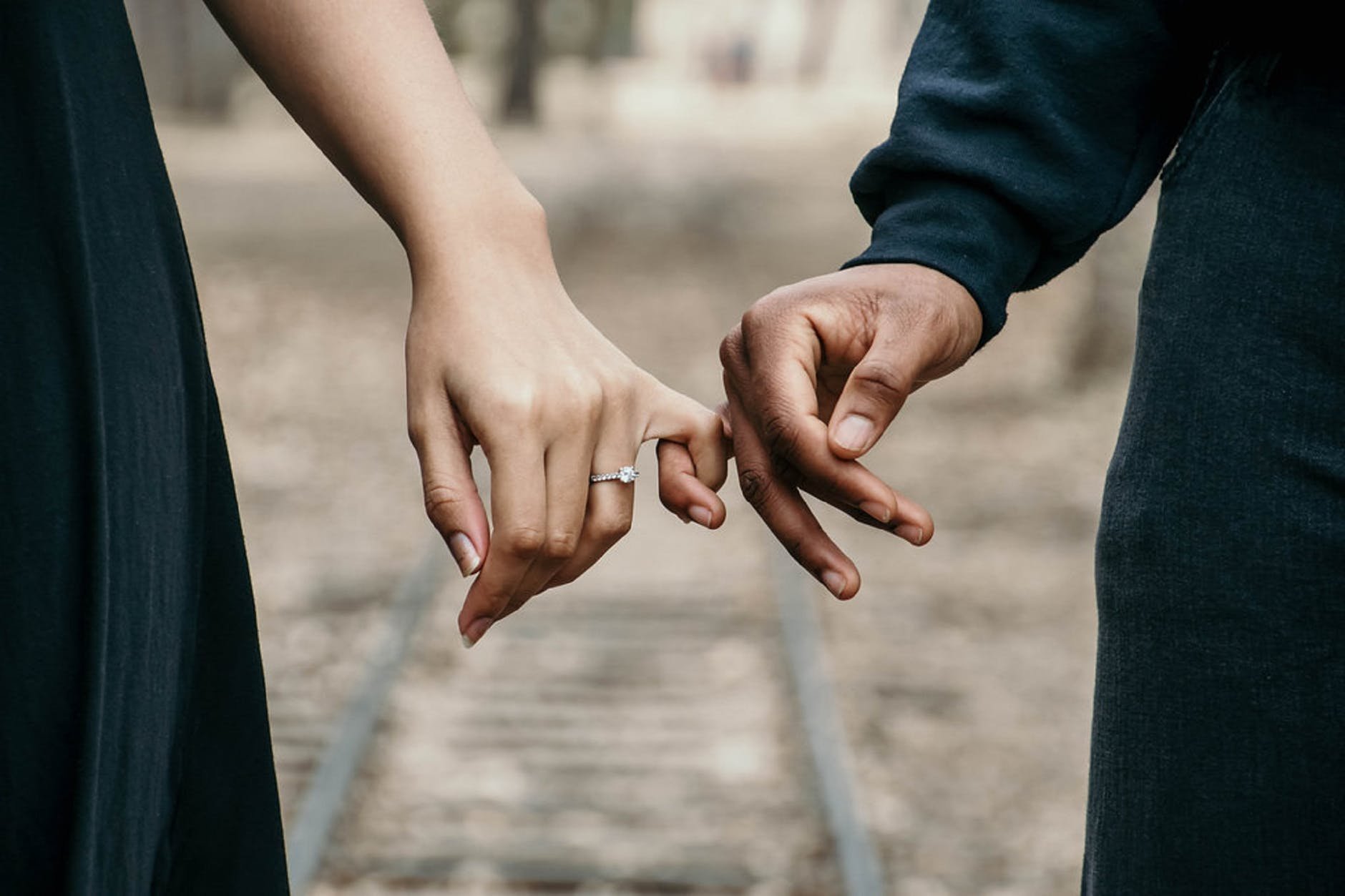 Deux mains avec des alliances tenant les petits doigts, symbolisant l'union et les couples de BW La Demeure Paris.