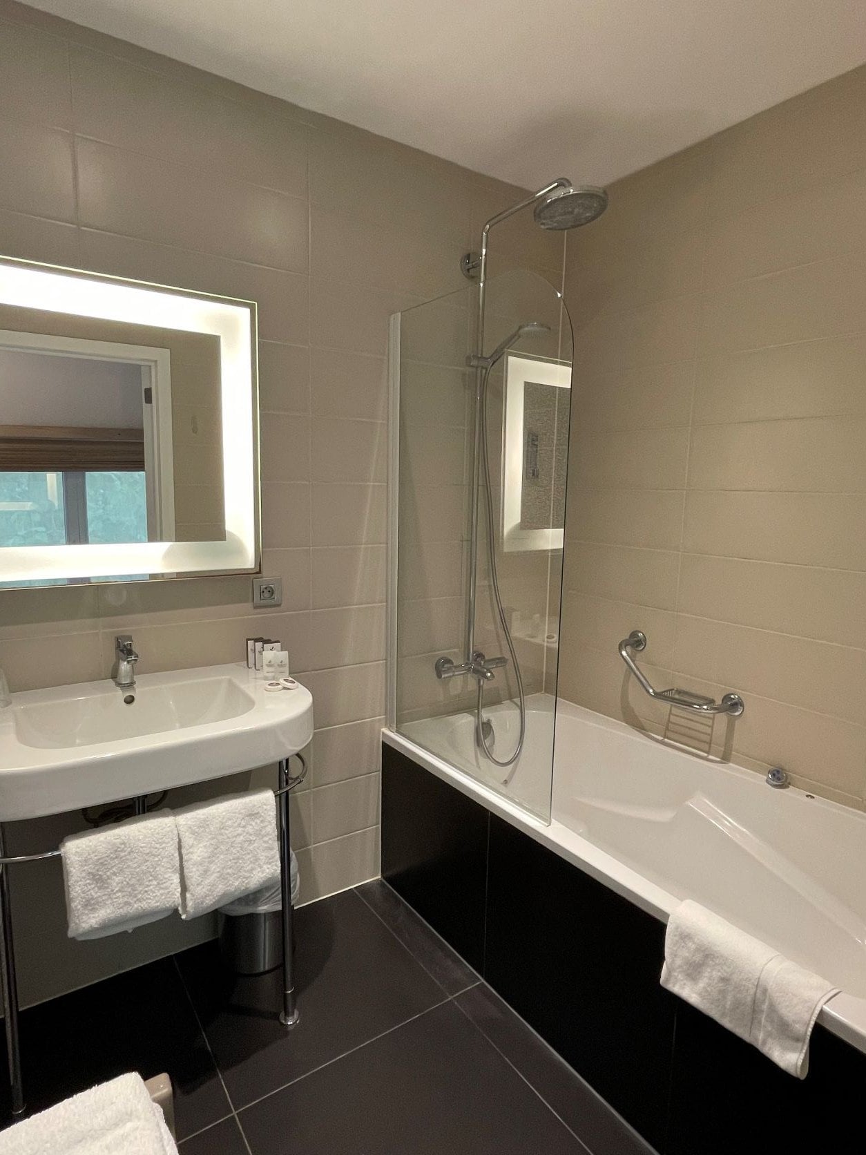 Elegante badkamer met ruime douche en mozaïektegels.