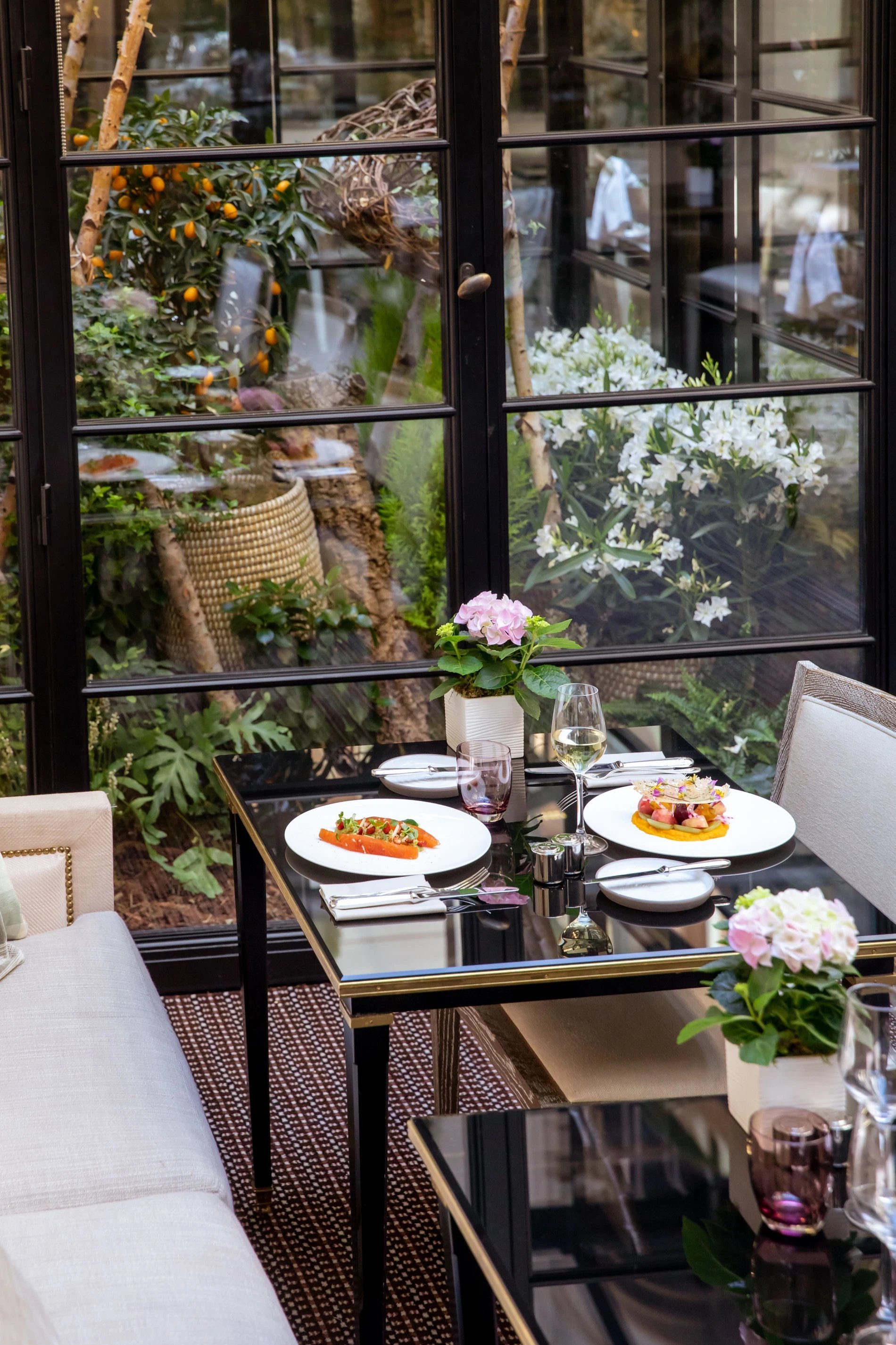 Elegant restaurant table with refined dishes and garden view