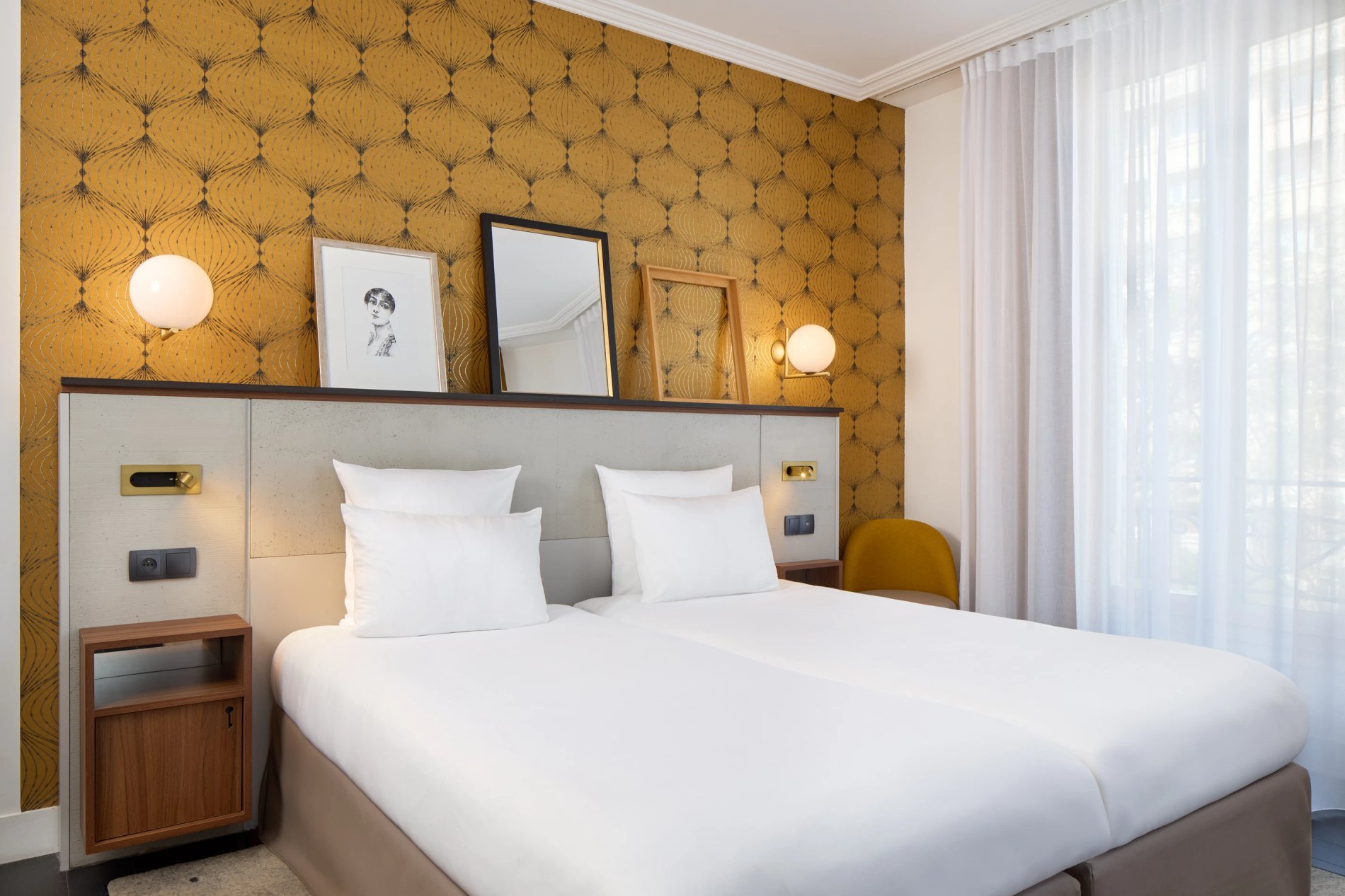 Chambre double classique avec lit et cadres muraux, symbolisant le design des chambres de BW La Demeure Paris.