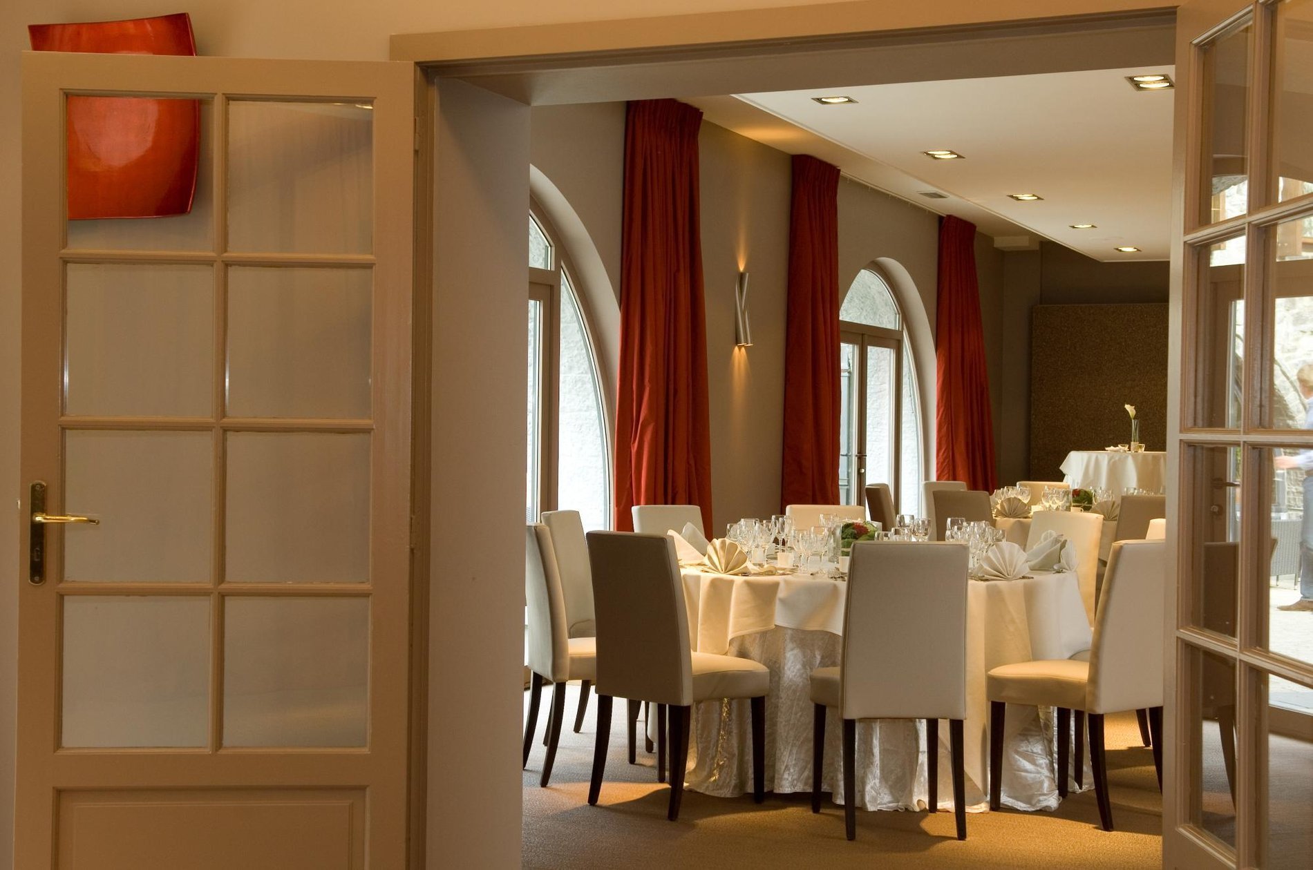 Elegant reception room with set tables and large windows at Martin's Château du Lac.