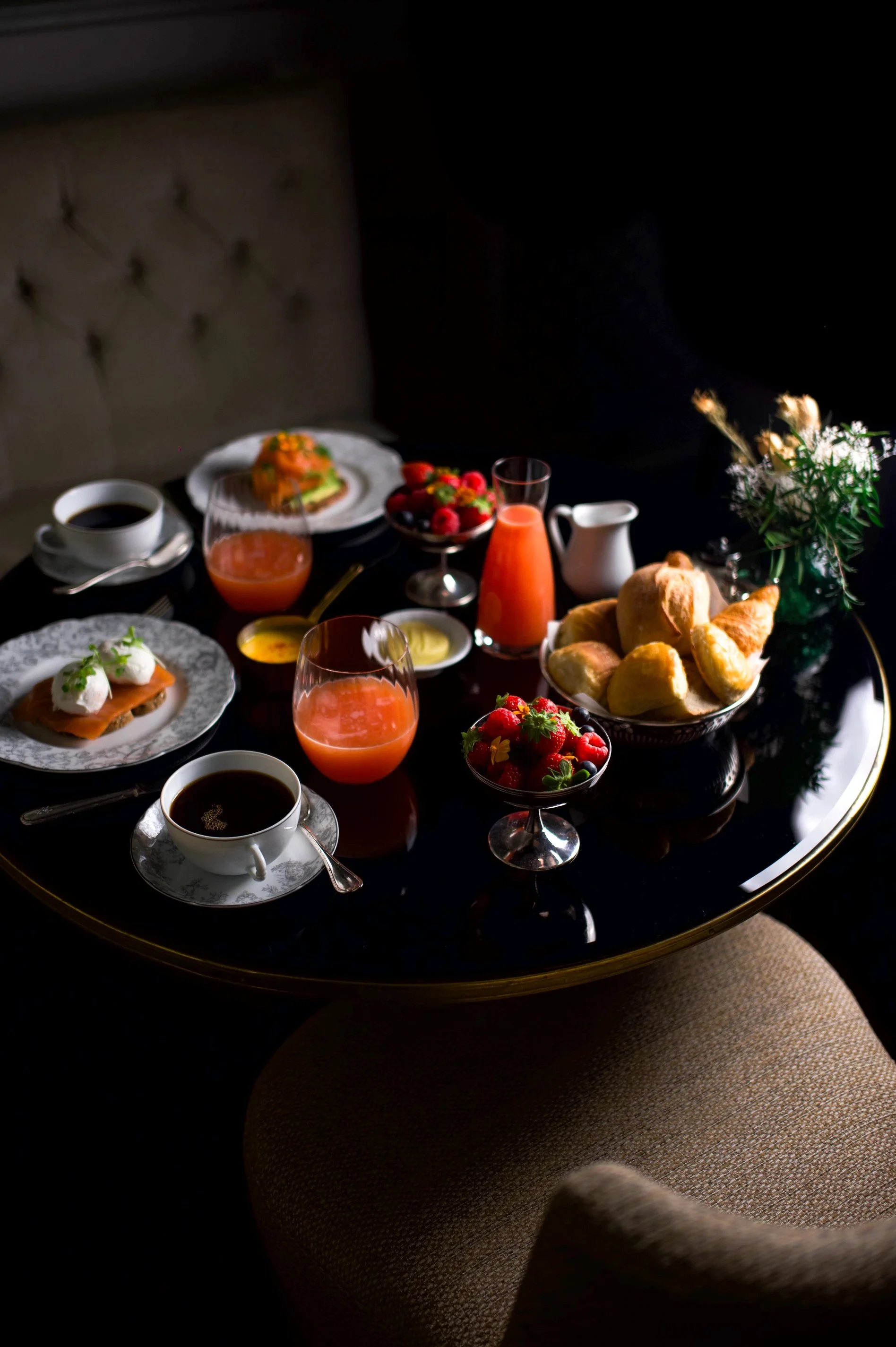 Table de petit-déjeuner à l’Hôtel San Régis Paris : jus frais, café, viennoiseries et fruits pour un réveil gourmet.